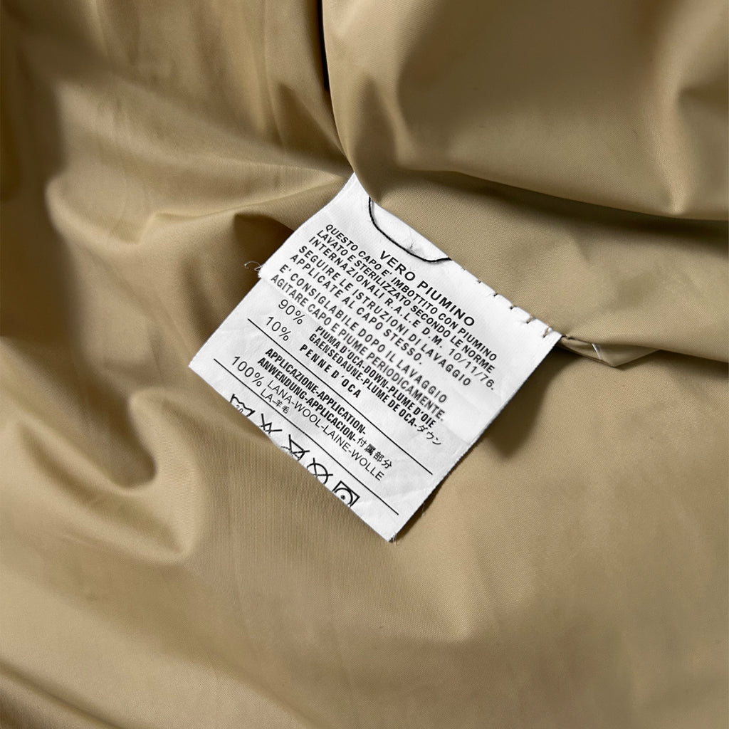 a close-up view of a fabric label, which is attached to a piece of fabric. The label contains text that provides information about the fabric, such as its material, care instructions, and washing instructions.