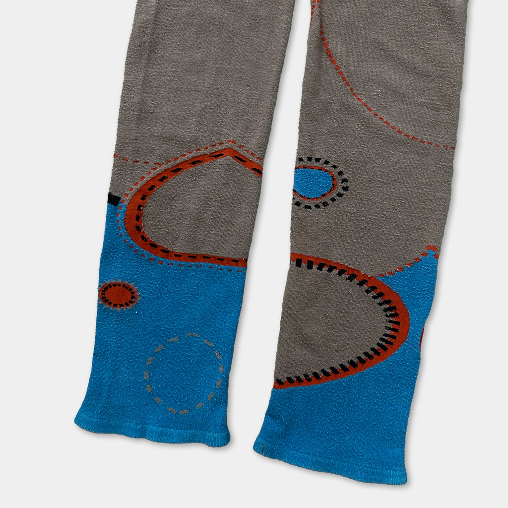 a pair of gray and blue patterned socks or stockings with a circular design and a blue circle motif.