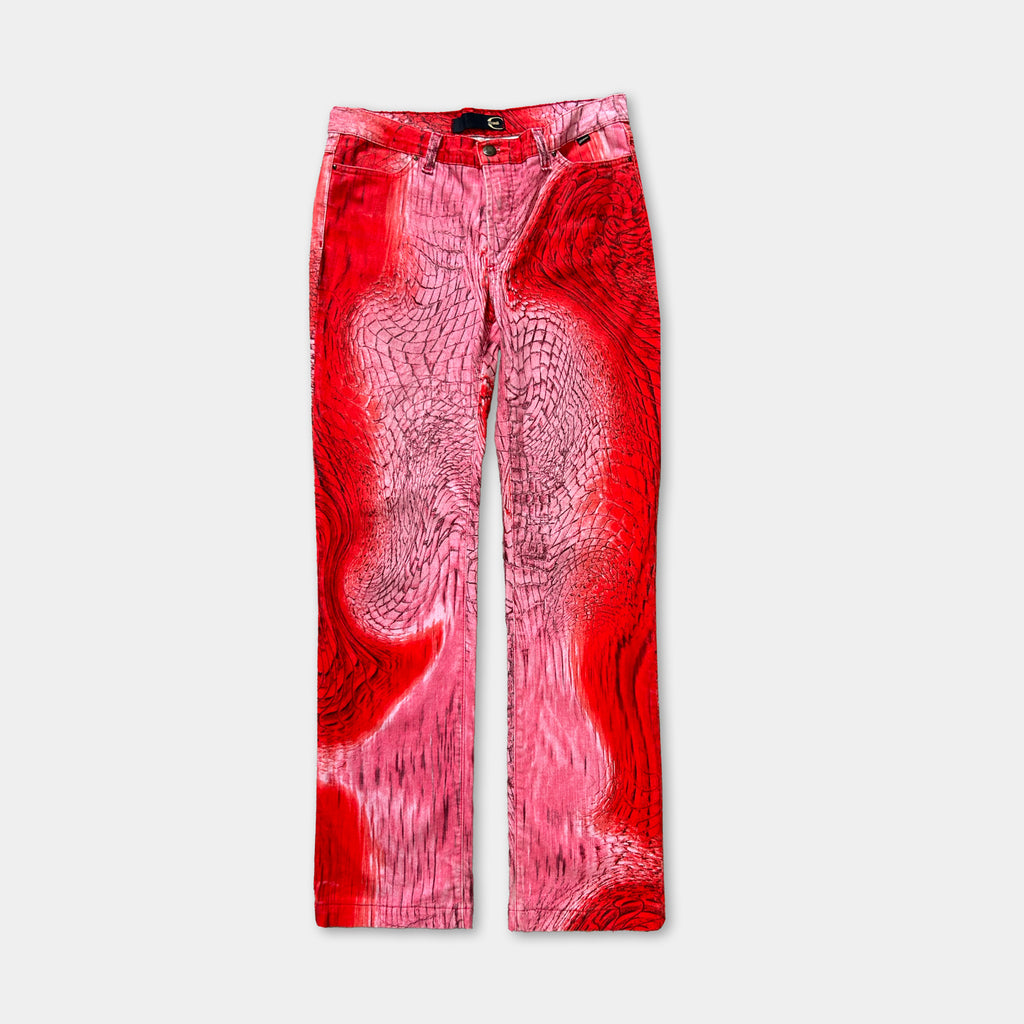 A pair of red pants with a unique, abstract pattern on the fabric.