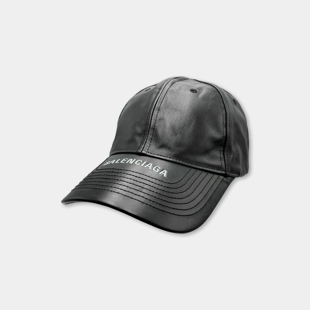 A black baseball cap with the word "Balenciaga" printed on it.