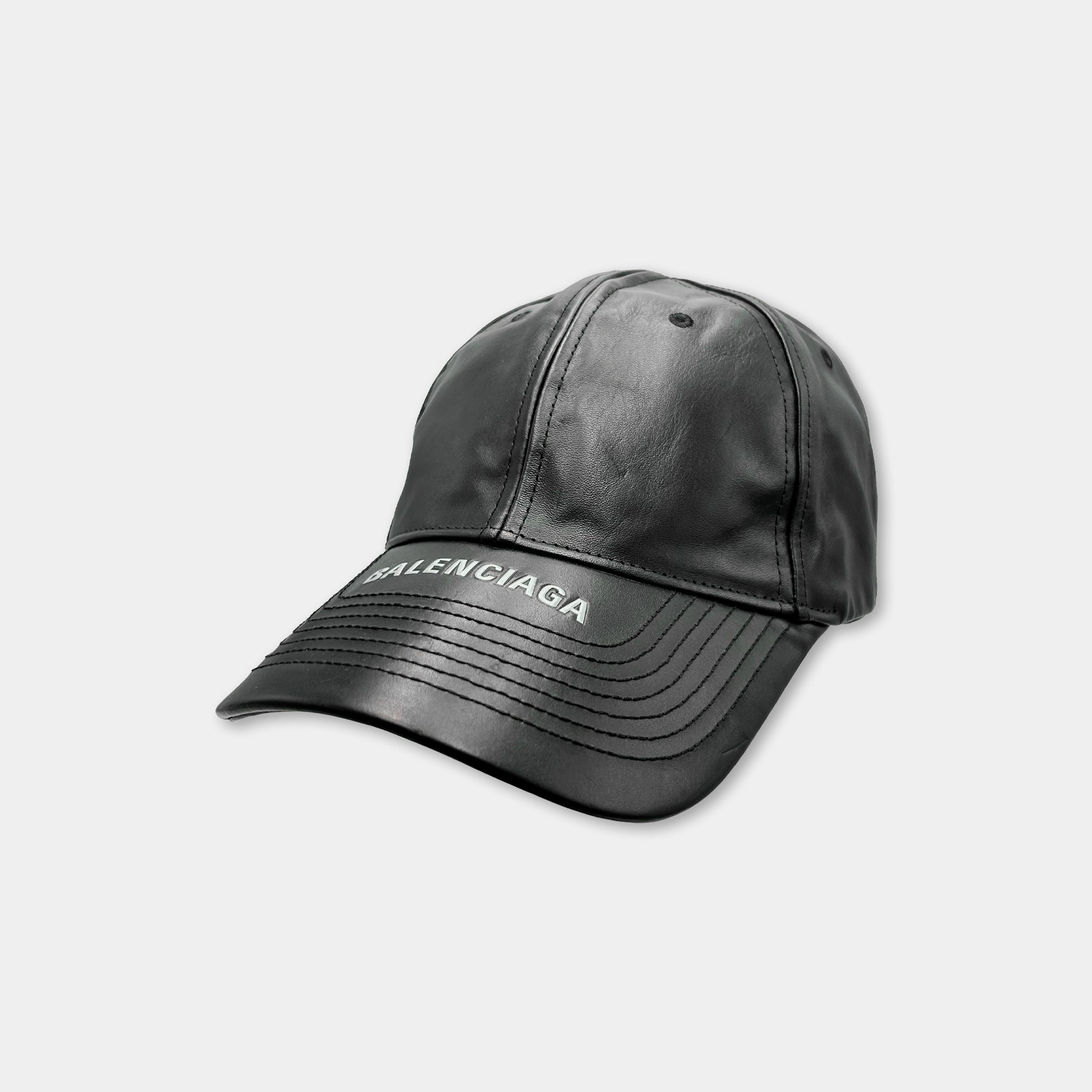 A black baseball cap with the word "Balenciaga" printed on it.