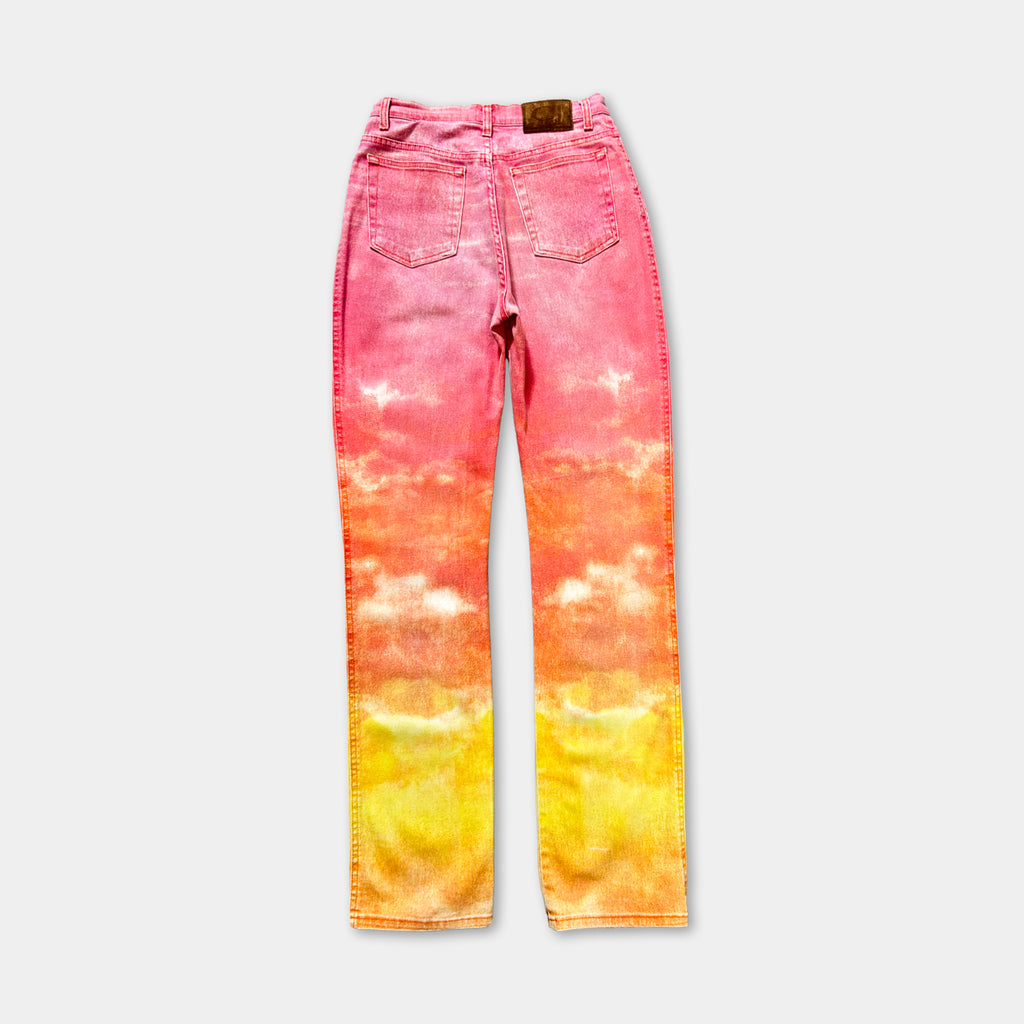 A pair of high-waisted, tie-dye jeans with a vibrant gradient of pink and yellow colors.