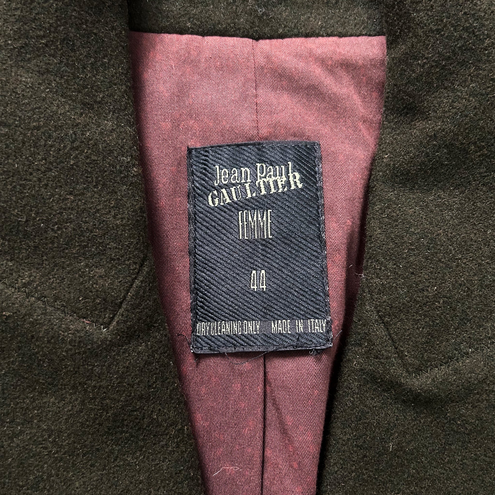 a close-up view of a dark-colored jacket with a label on the inside lining.