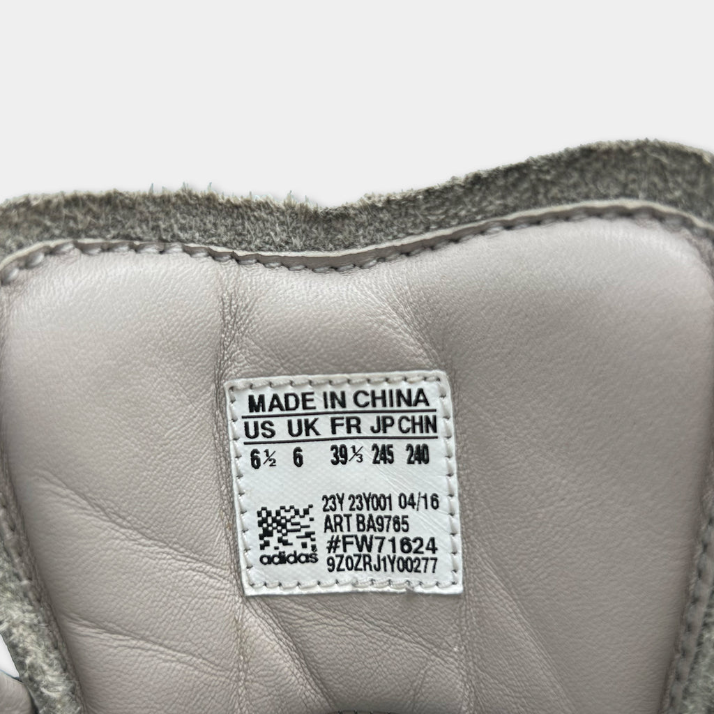 a close-up view of a white Adidas sneaker, with a label indicating that it is made in China.
