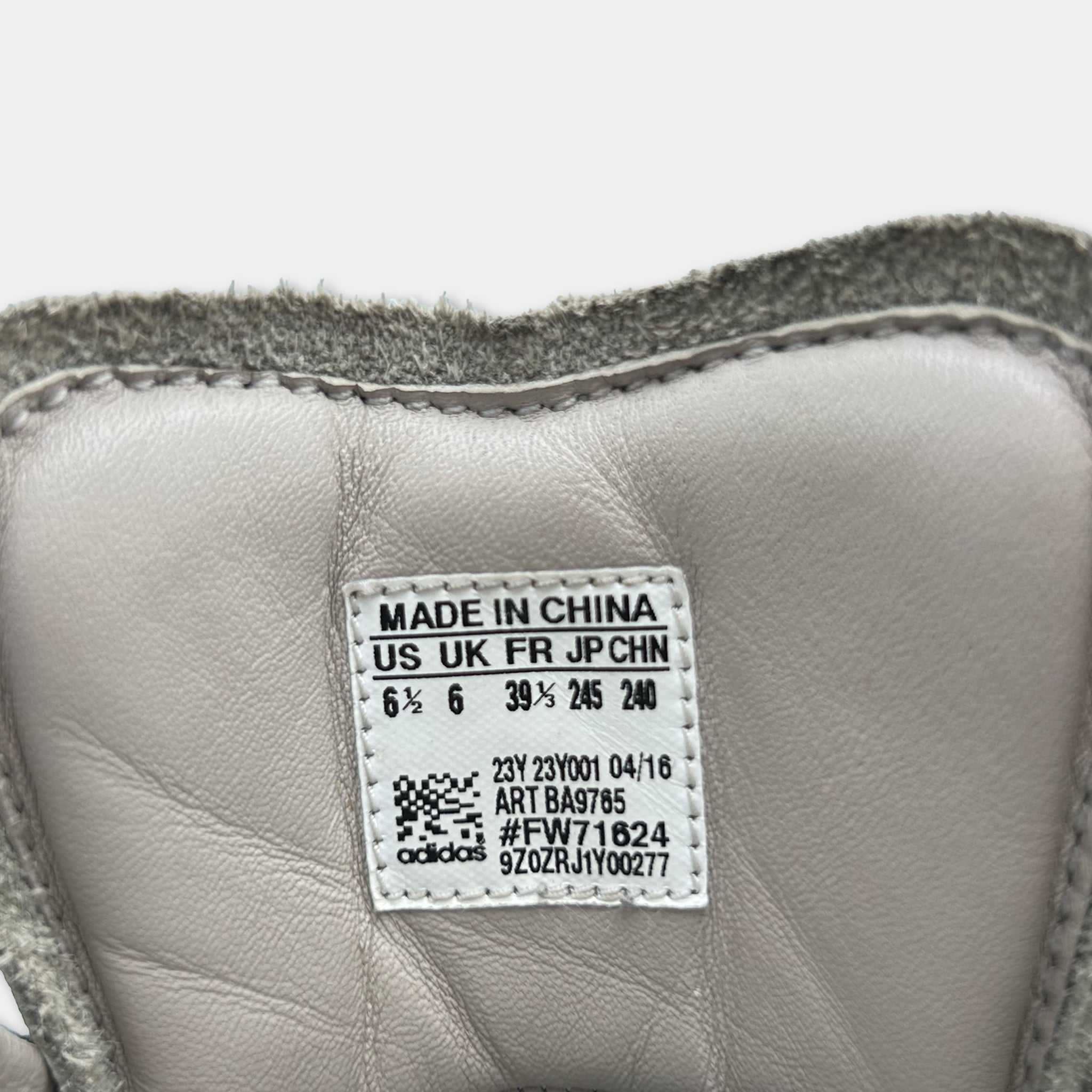 a close-up view of a white Adidas sneaker, with a label indicating that it is made in China.