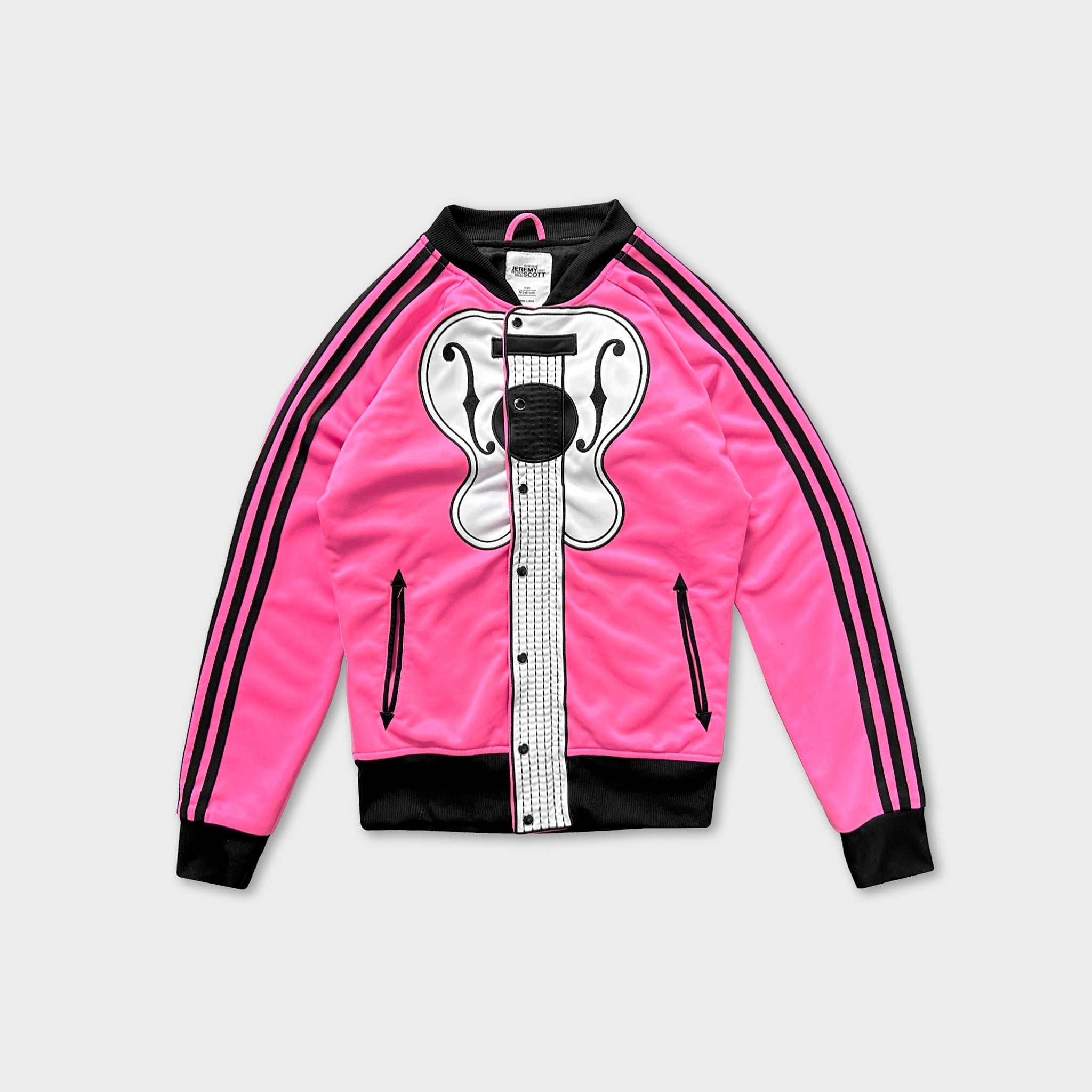 A bright pink track jacket with black stripes and a graphic of a guitar on the front.