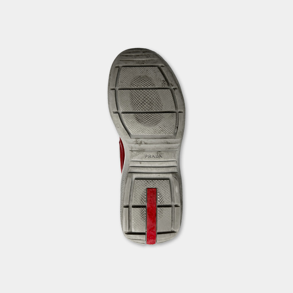 A single, worn shoe sole with a red stripe on the side.