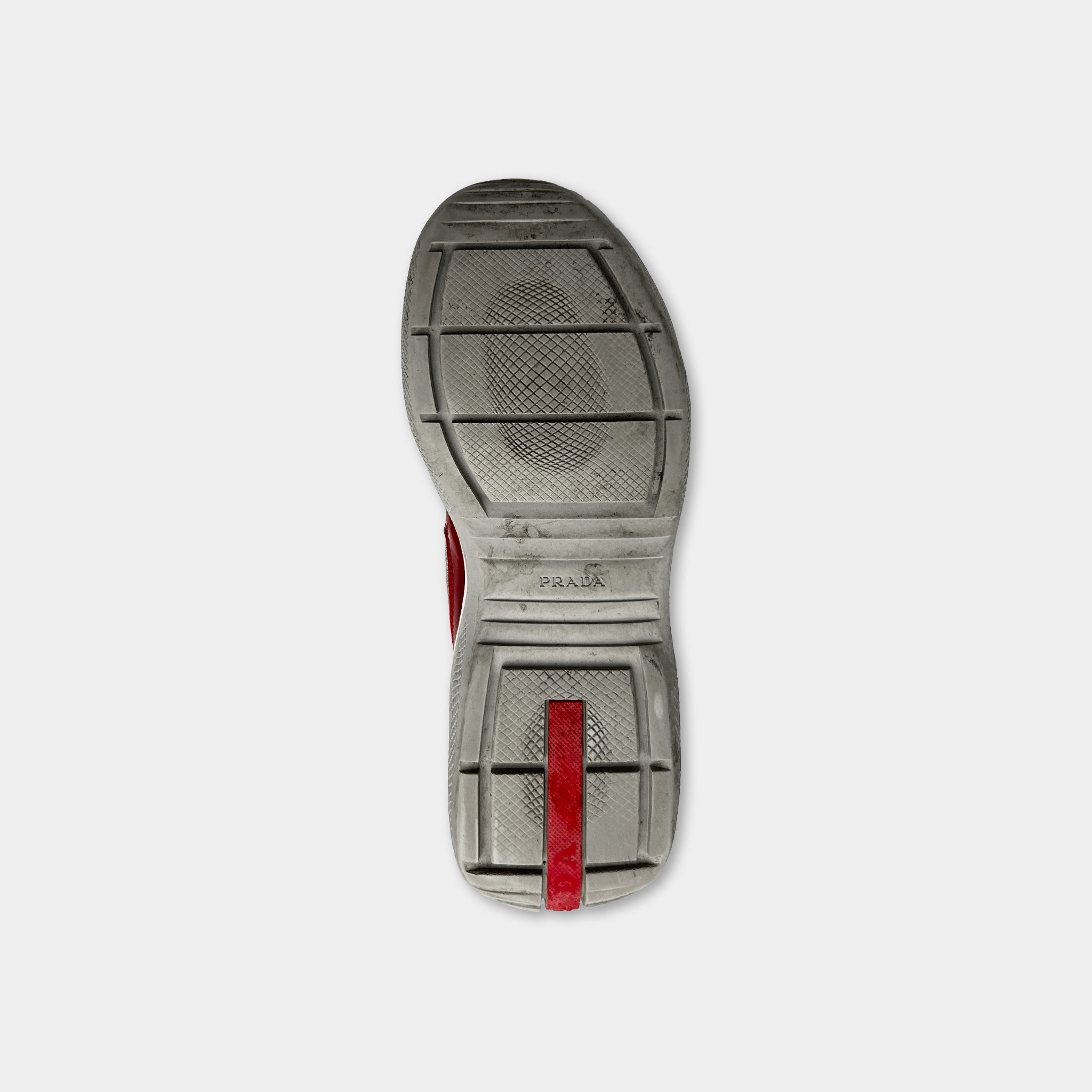 A single, worn shoe sole with a red stripe on the side.