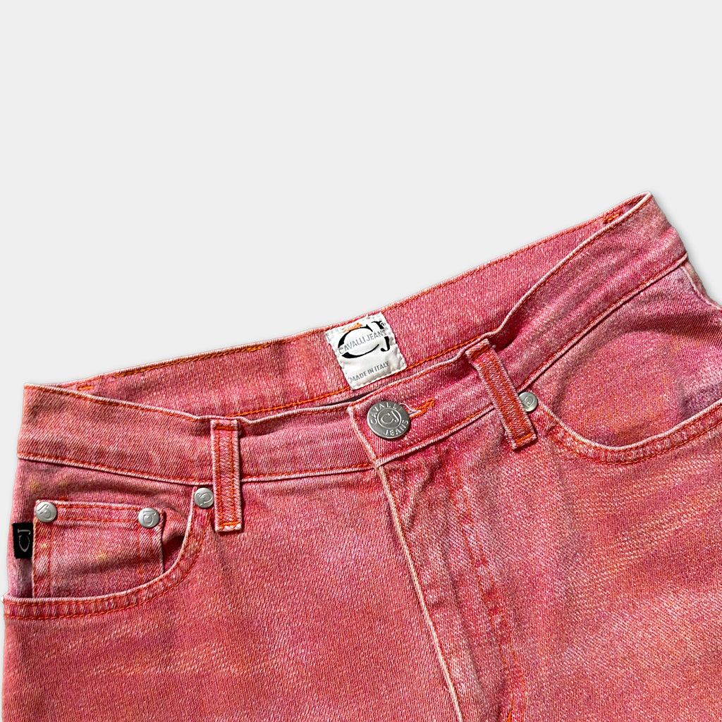 A pair of red denim jeans with a label on the waistband.