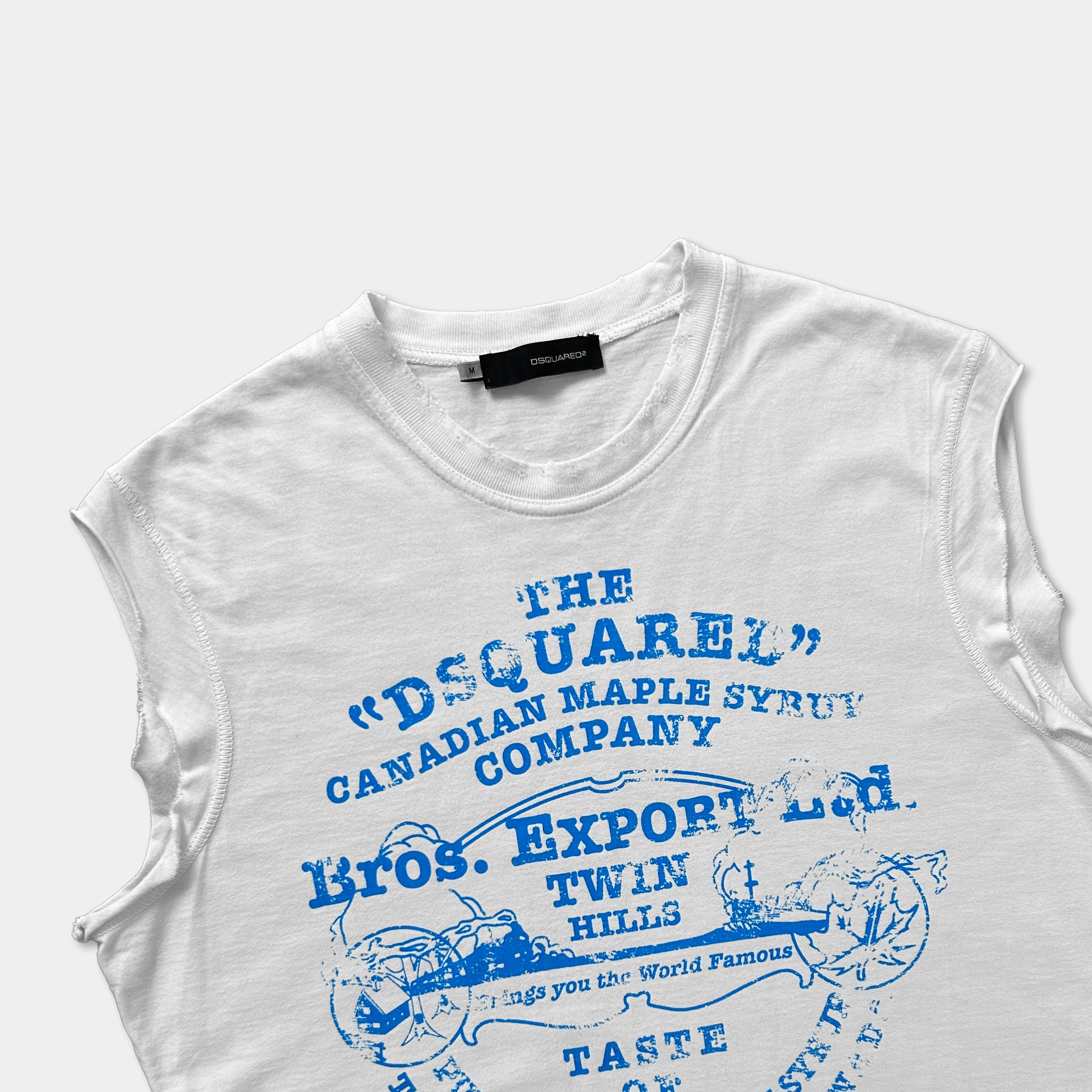 A white sleeveless t-shirt with a blue printed design featuring text and graphics related to the Canadian Maple Syrup Company.