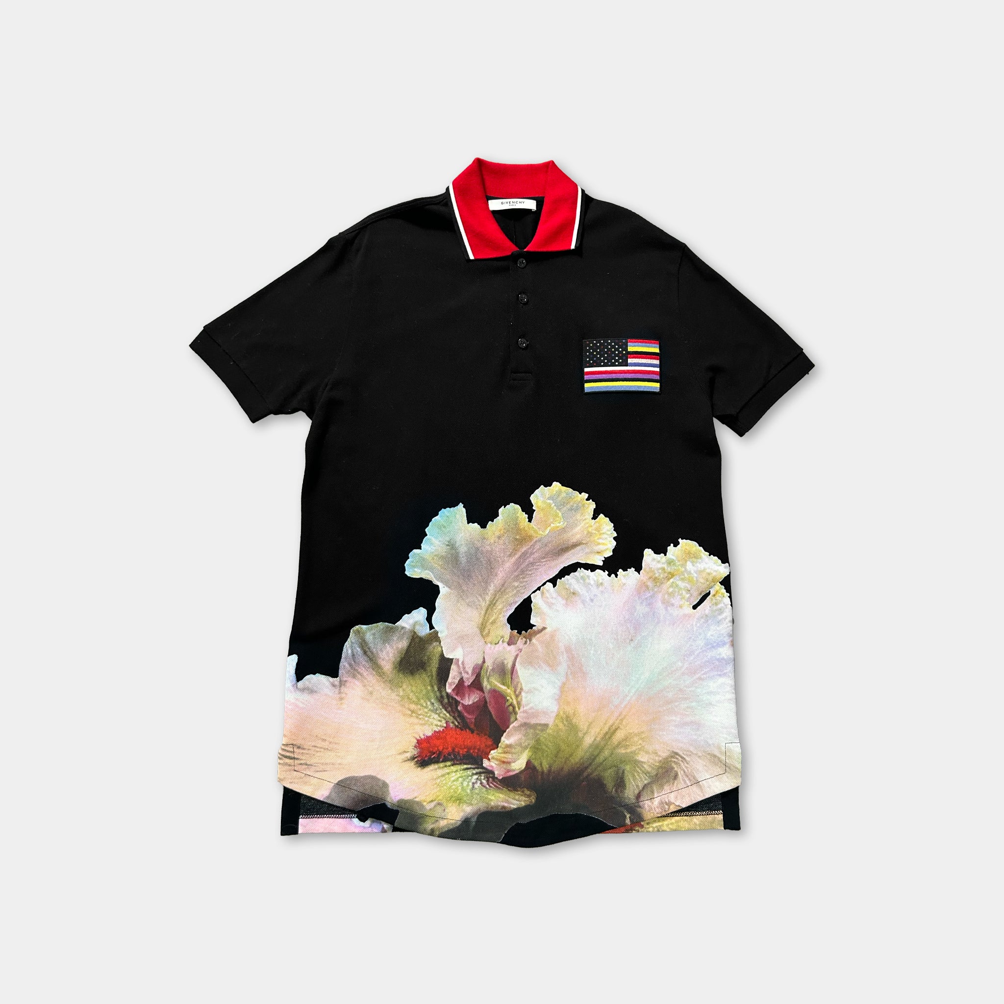A black polo shirt with a red collar and a colorful graphic of a flower printed on the front.