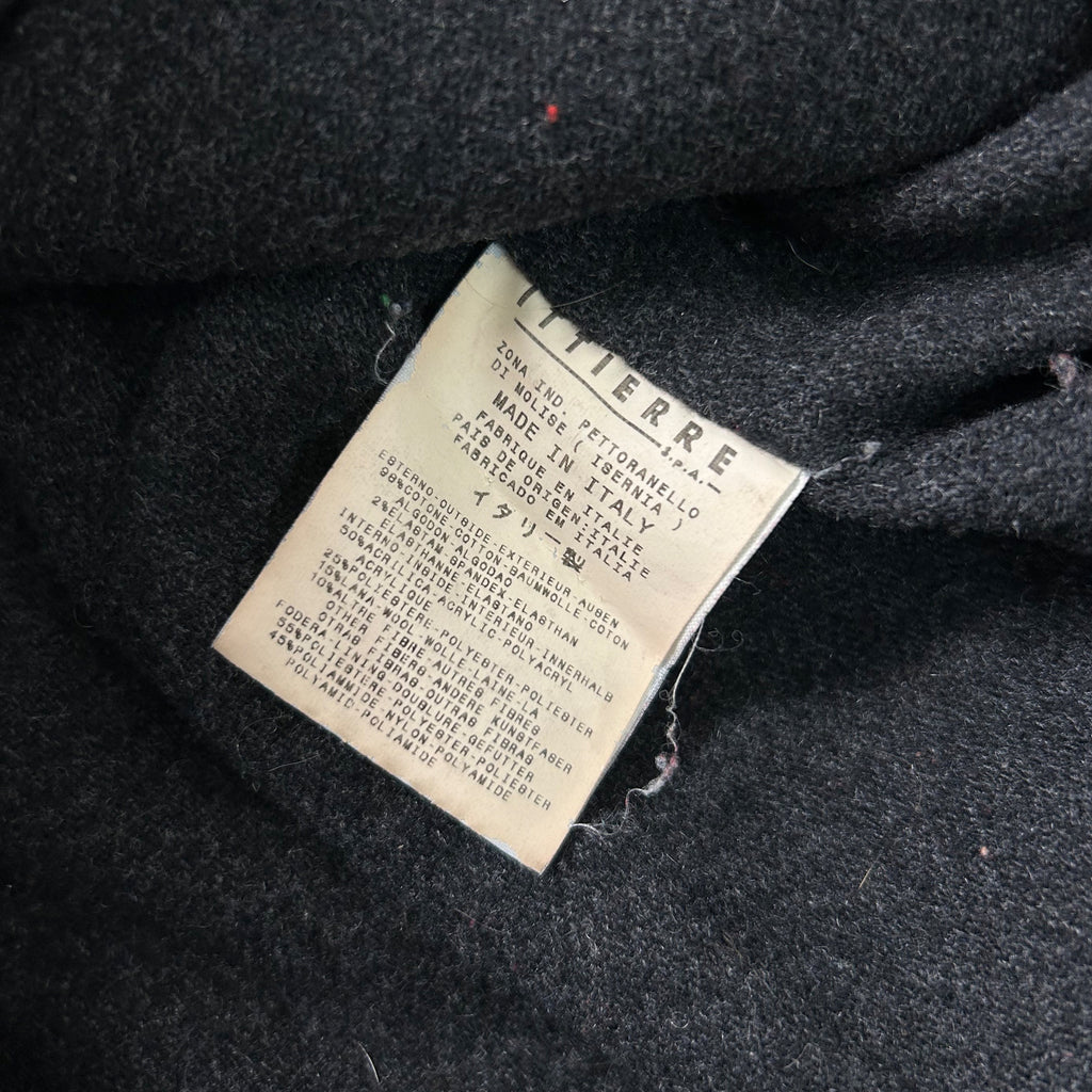 a close-up view of a black fabric, possibly a sweater or garment, with a label attached to it. The label appears to contain text in a foreign language, which is not clearly visible due to the angle and focus of the photograph.