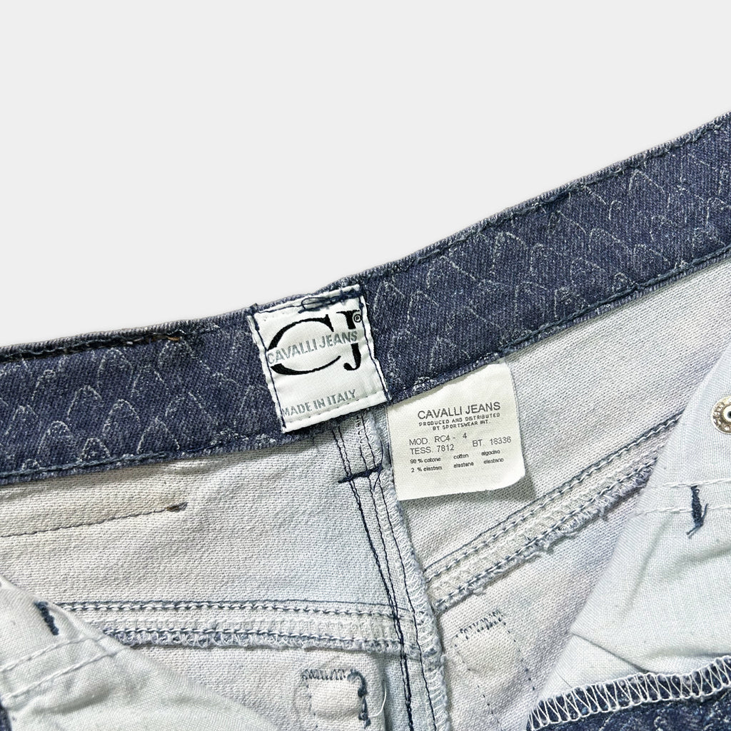 a close-up view of a pair of jeans, focusing on the waistband and the label attached to the waistband.