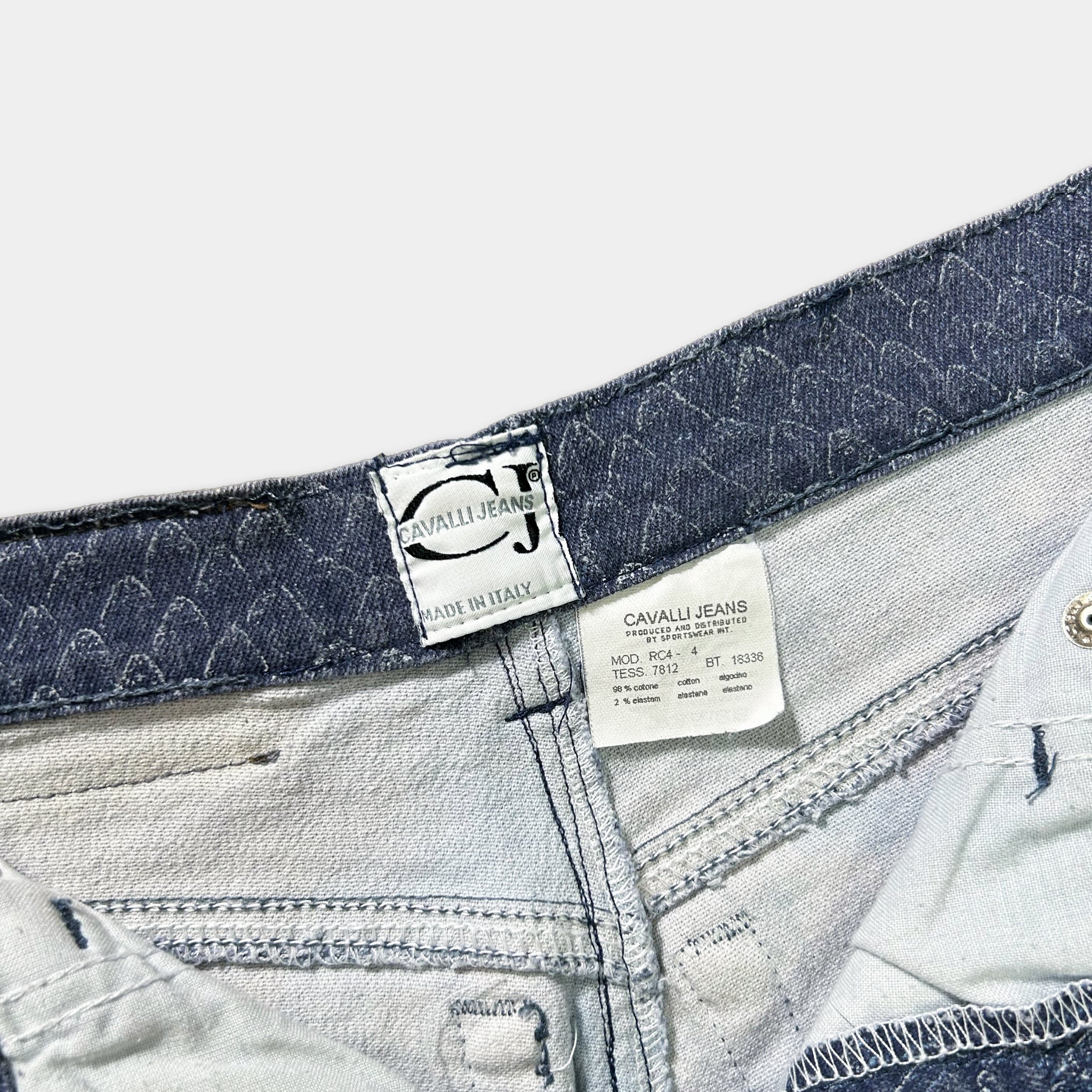 a close-up view of a pair of jeans, focusing on the waistband and the label attached to the waistband.