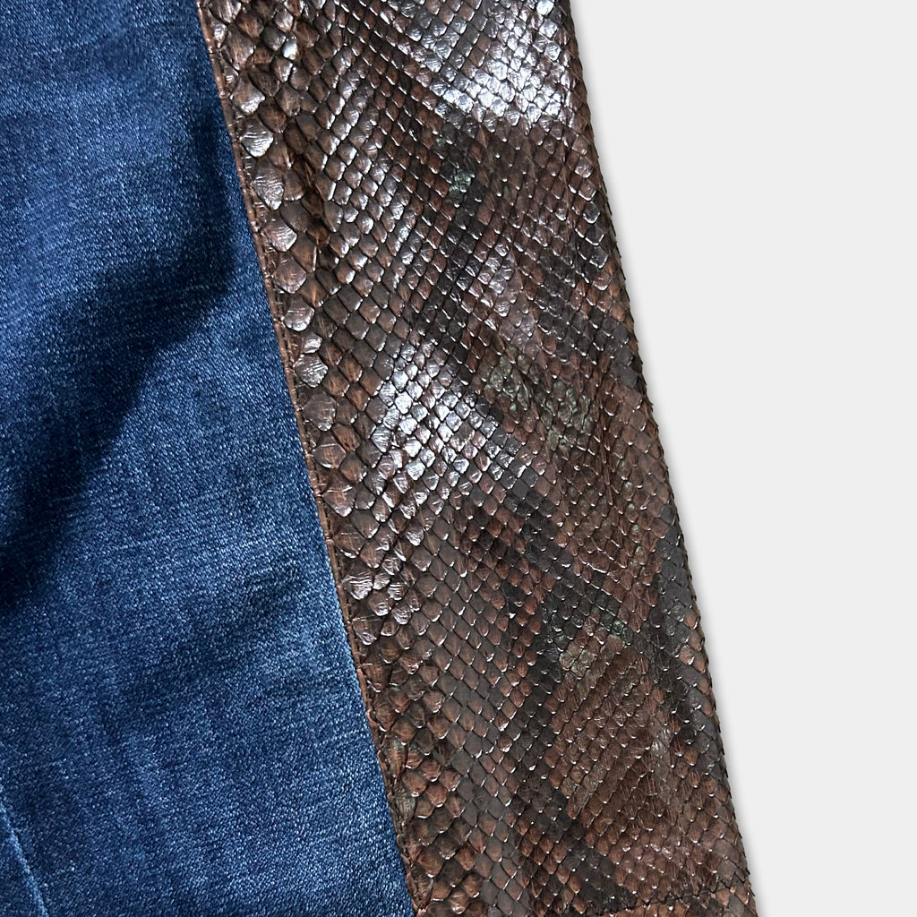 a close-up view of a piece of blue denim fabric with a brown, snake skin-like pattern on it.