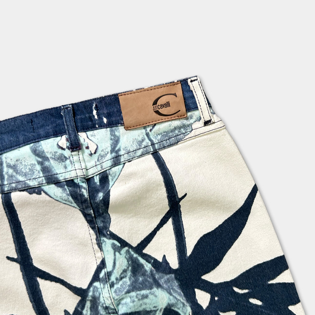 a pair of jeans with a distinctive pattern, featuring a combination of blue and white colors. The jeans appear to be made of denim fabric, and there is a label or tag attached to the waistband, which has a logo or text on it.