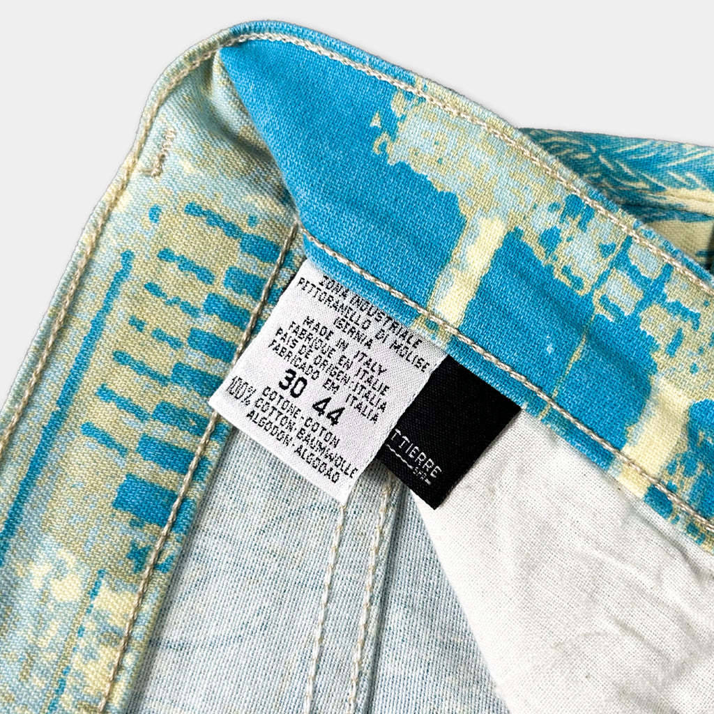 a close-up view of a label on a pair of blue jeans, with a patterned fabric visible.