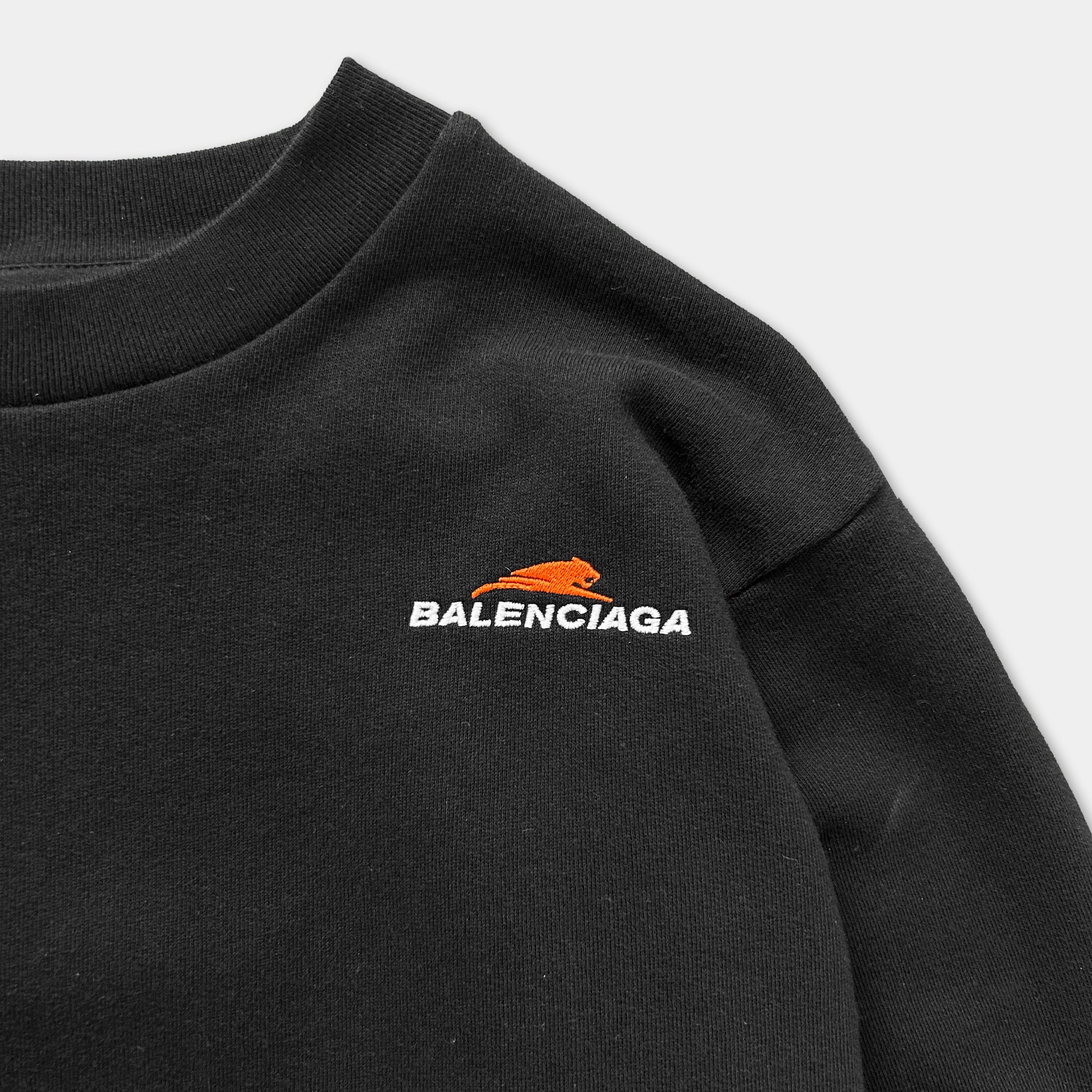 A black sweater with the Balenciaga logo printed on the front.