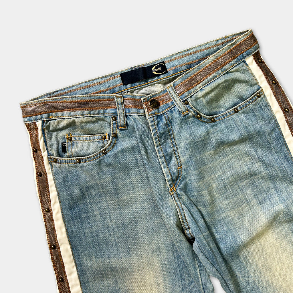 A pair of blue jeans with a brown belt and decorative stitching on the sides.