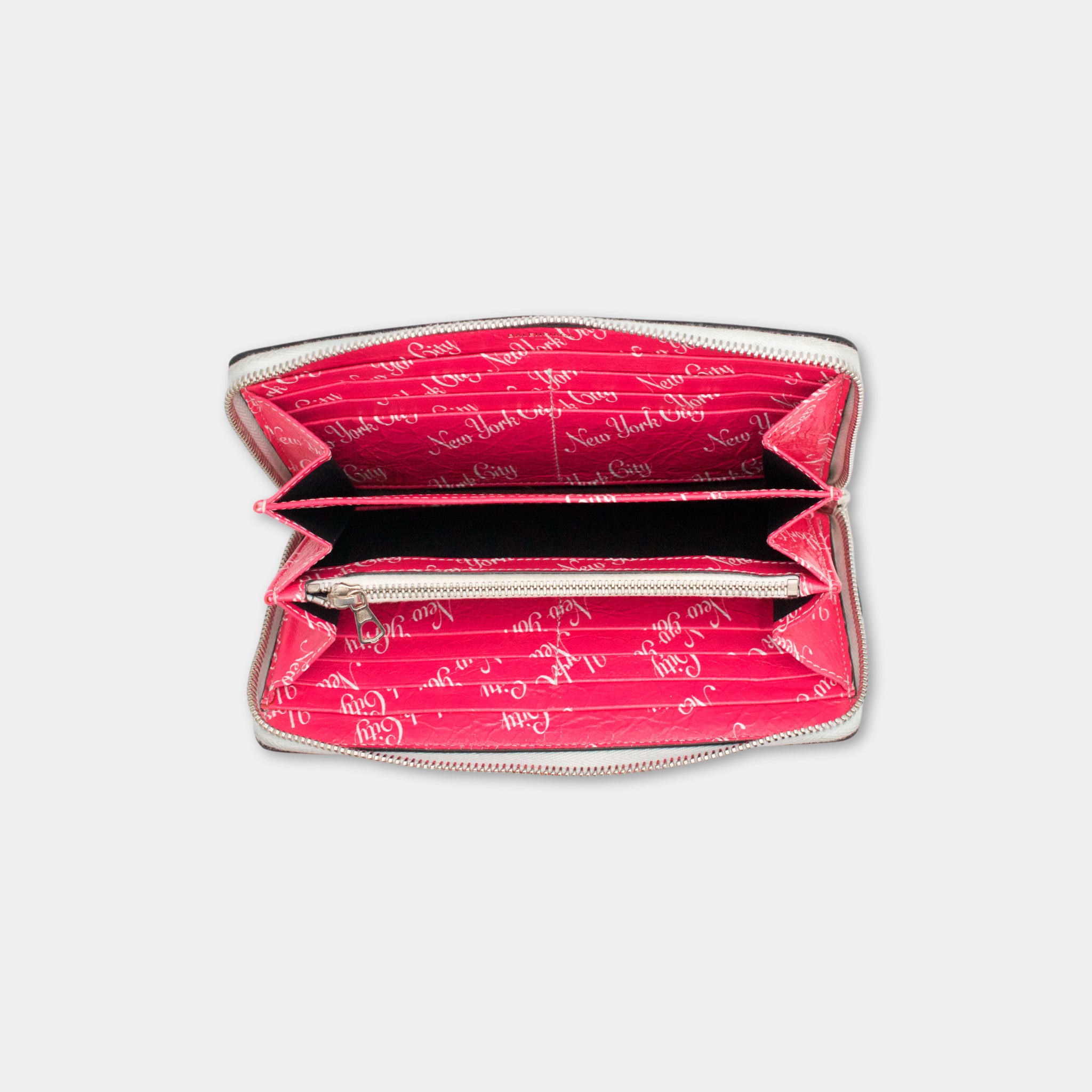 the inside of a pink wallet with a repeating pattern of text on the lining.