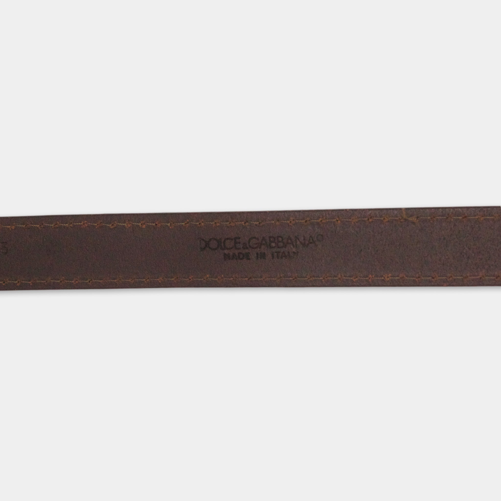 A close-up view of a brown leather belt with the brand name "Dolce & Gabbana" printed on it.
