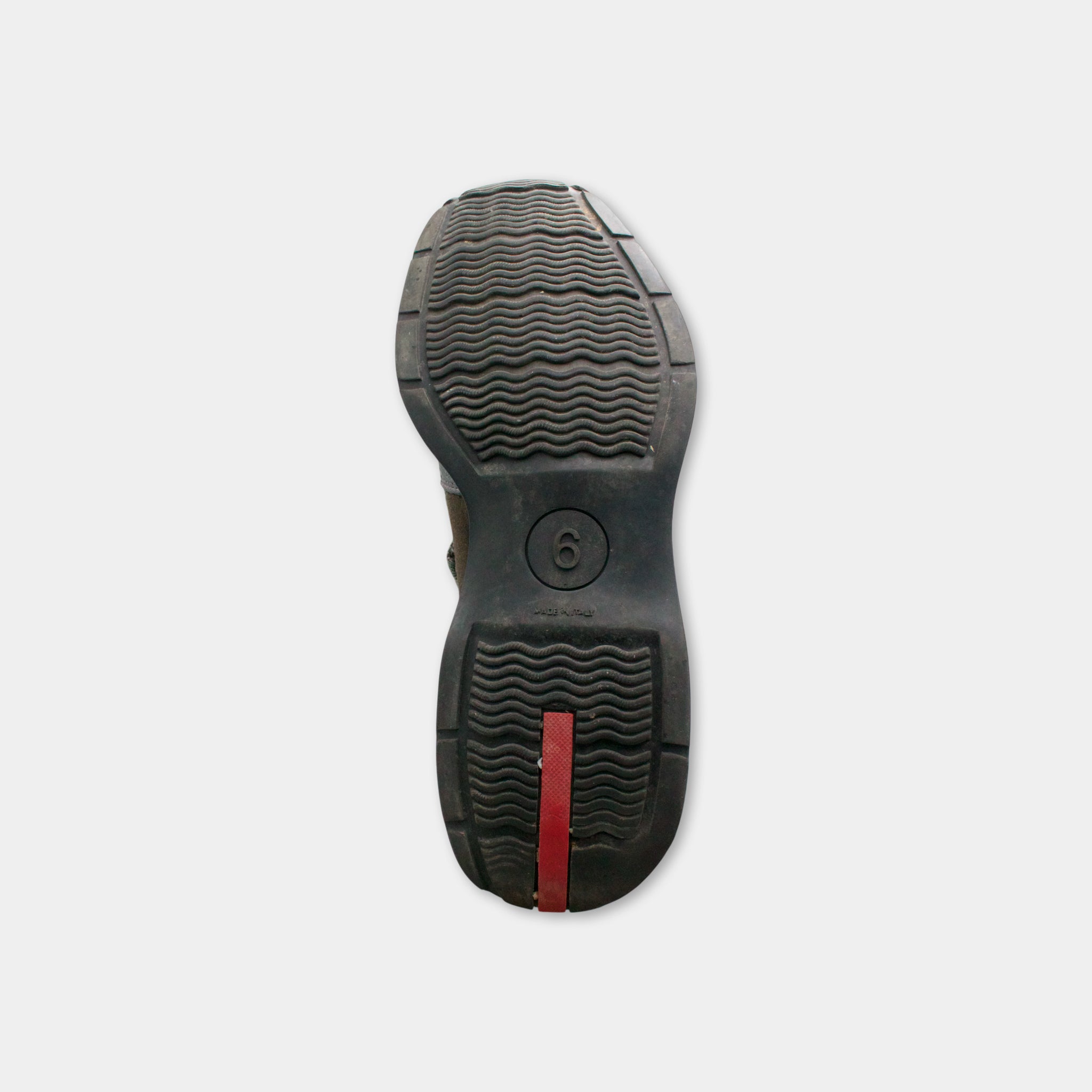 the sole of a black shoe with a red stripe on the side.