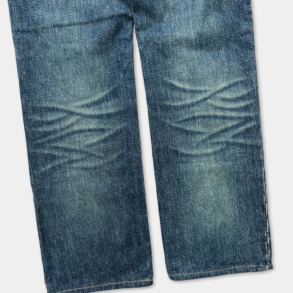 A close-up view of a pair of well-worn blue jeans with visible creases and folds, suggesting frequent use.