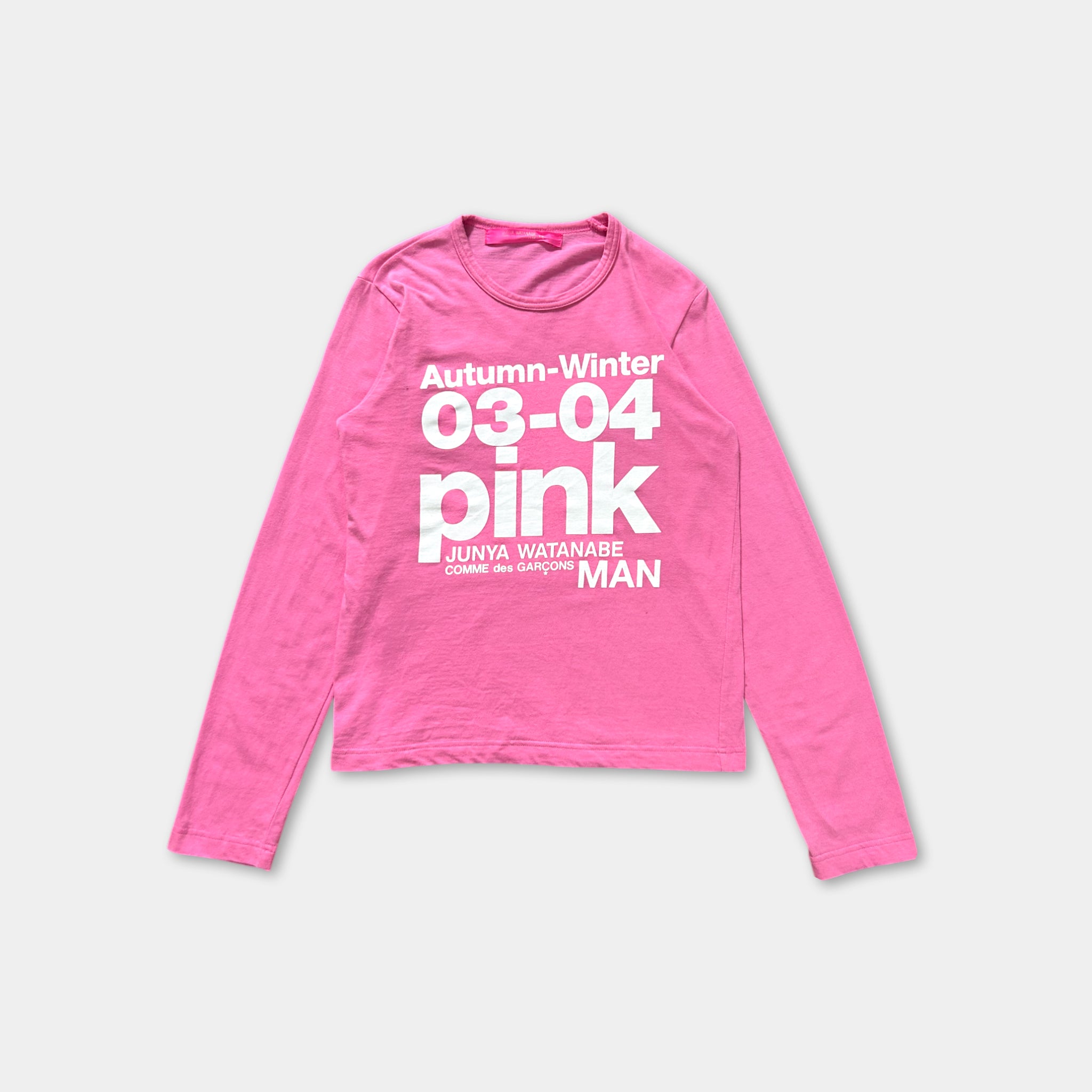 A pink long-sleeved shirt with white text printed on it.