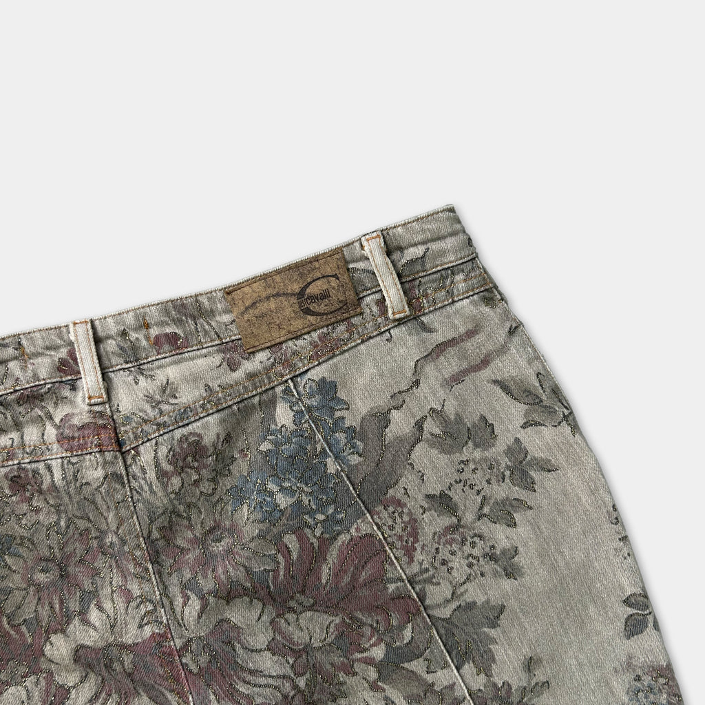 A pair of floral print jeans with a label on the waistband.