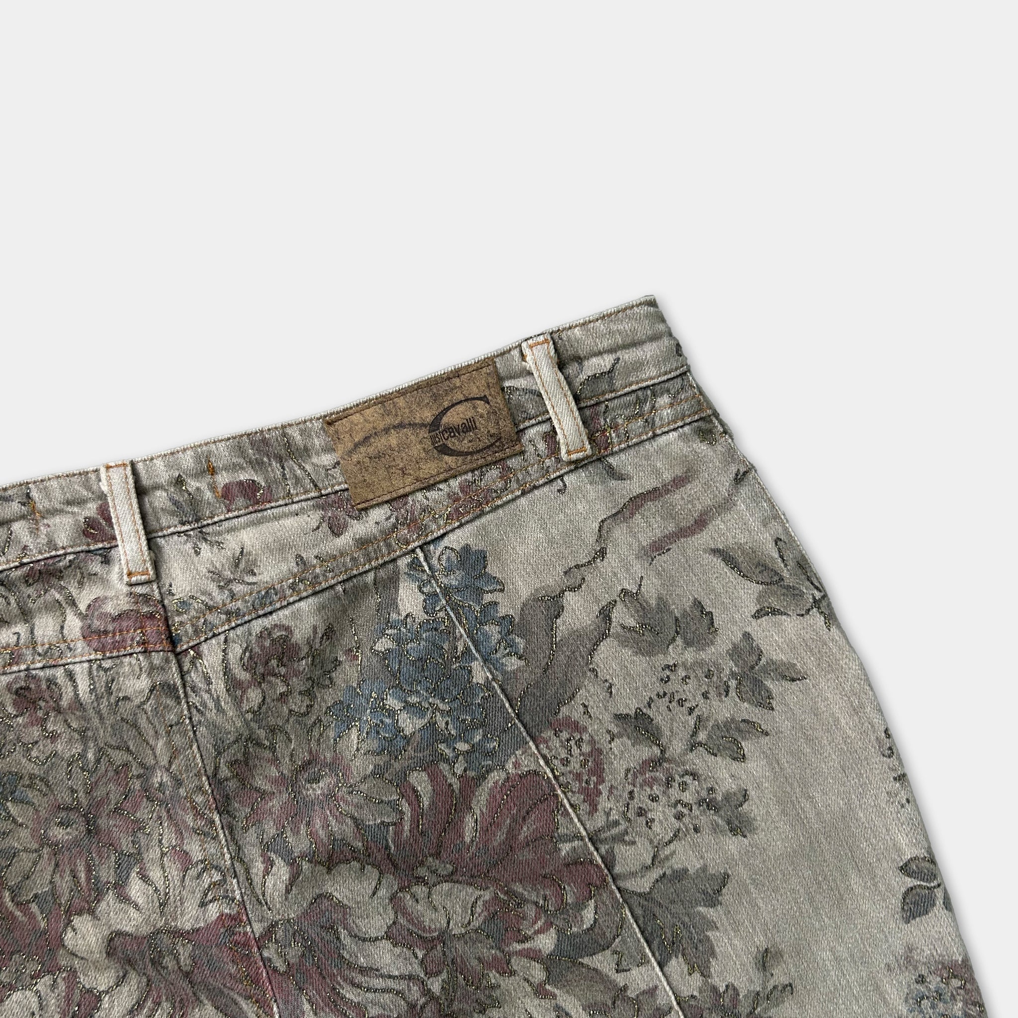 A pair of floral print jeans with a label on the waistband.