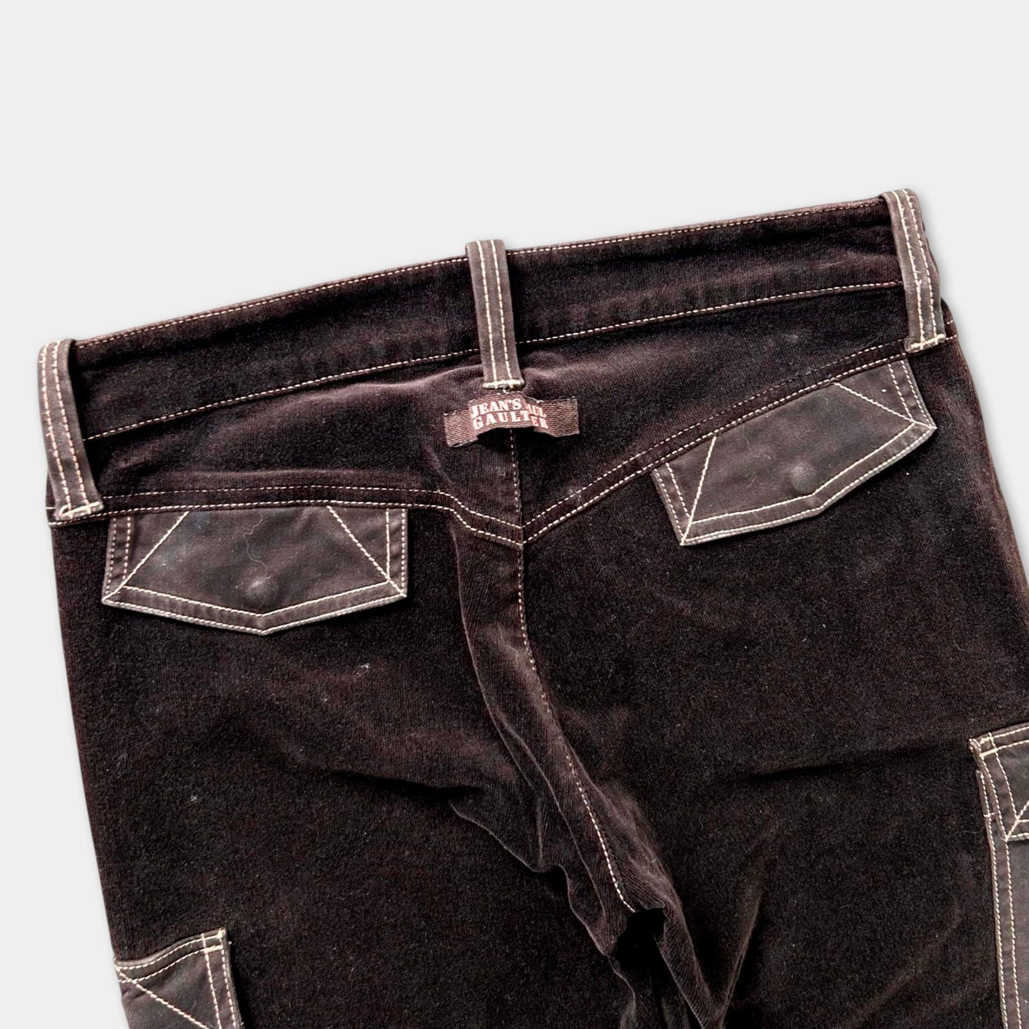 A pair of dark brown velvet pants with a label on the waistband.