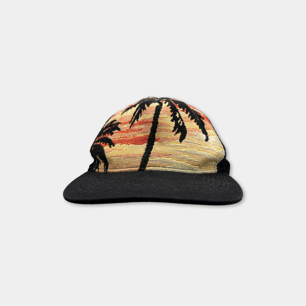A black baseball cap with a palm tree design printed on it.