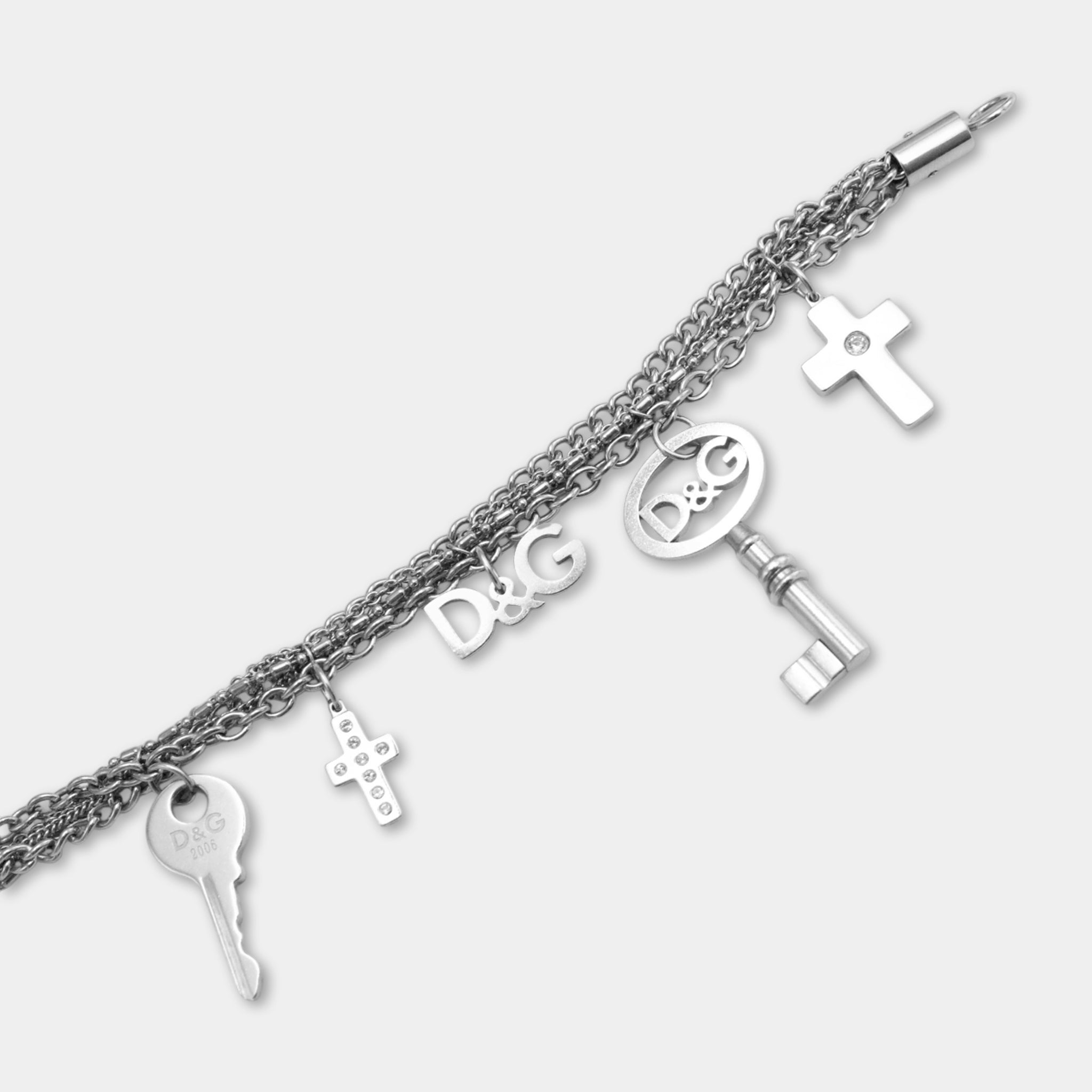 A silver-colored bracelet with various charms, including a key, cross, and other symbols, attached to it.