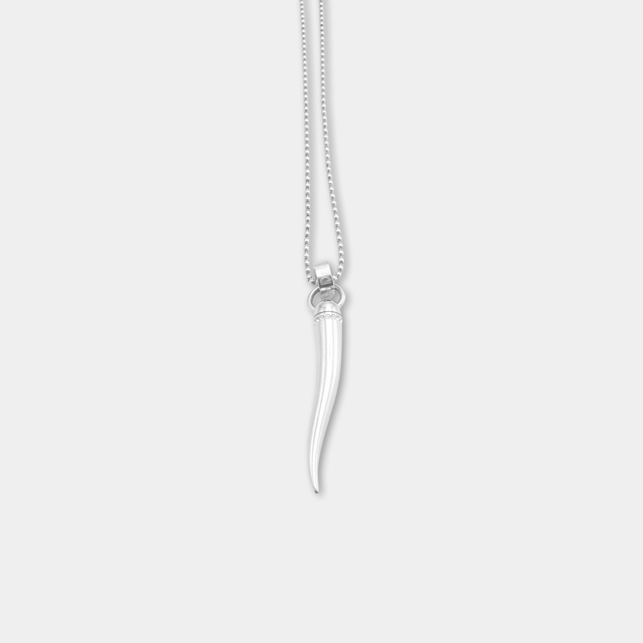 A silver necklace with a pendant featuring a long, thin, white object hanging from it.
