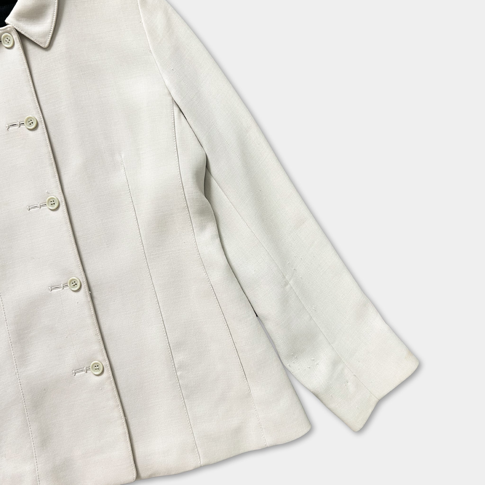 A white jacket with buttons and a collar is shown in the image.