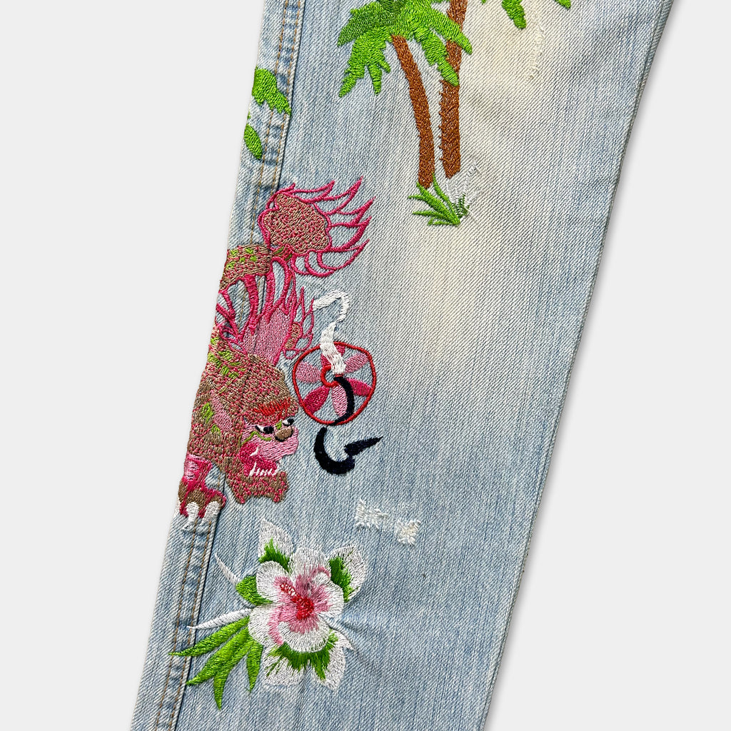 a pair of light blue jeans with colorful floral and dragon embroidery designs.