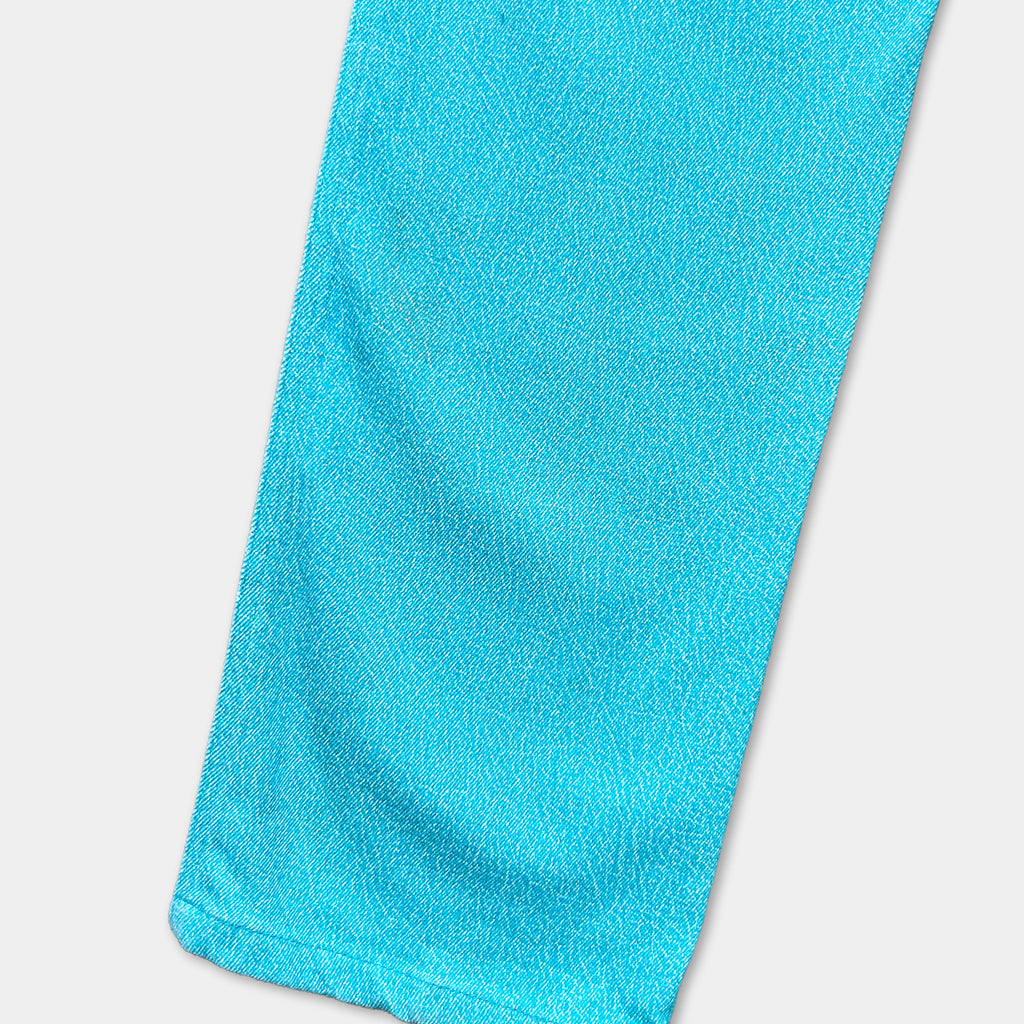 A close-up view of a bright blue fabric, possibly a piece of clothing or a textile, with a textured and wrinkled appearance.