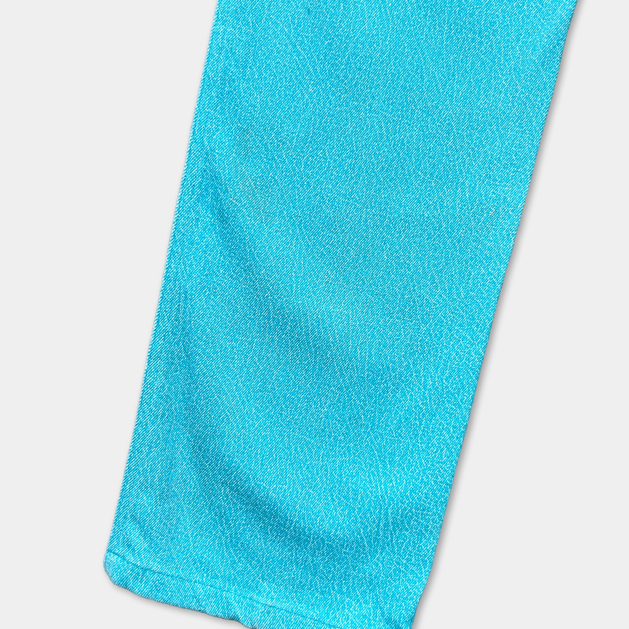 A close-up view of a bright blue fabric, possibly a piece of clothing or a textile, with a textured and wrinkled appearance.