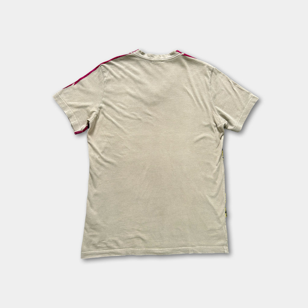 a plain, beige t-shirt with a red stripe on the sleeve.