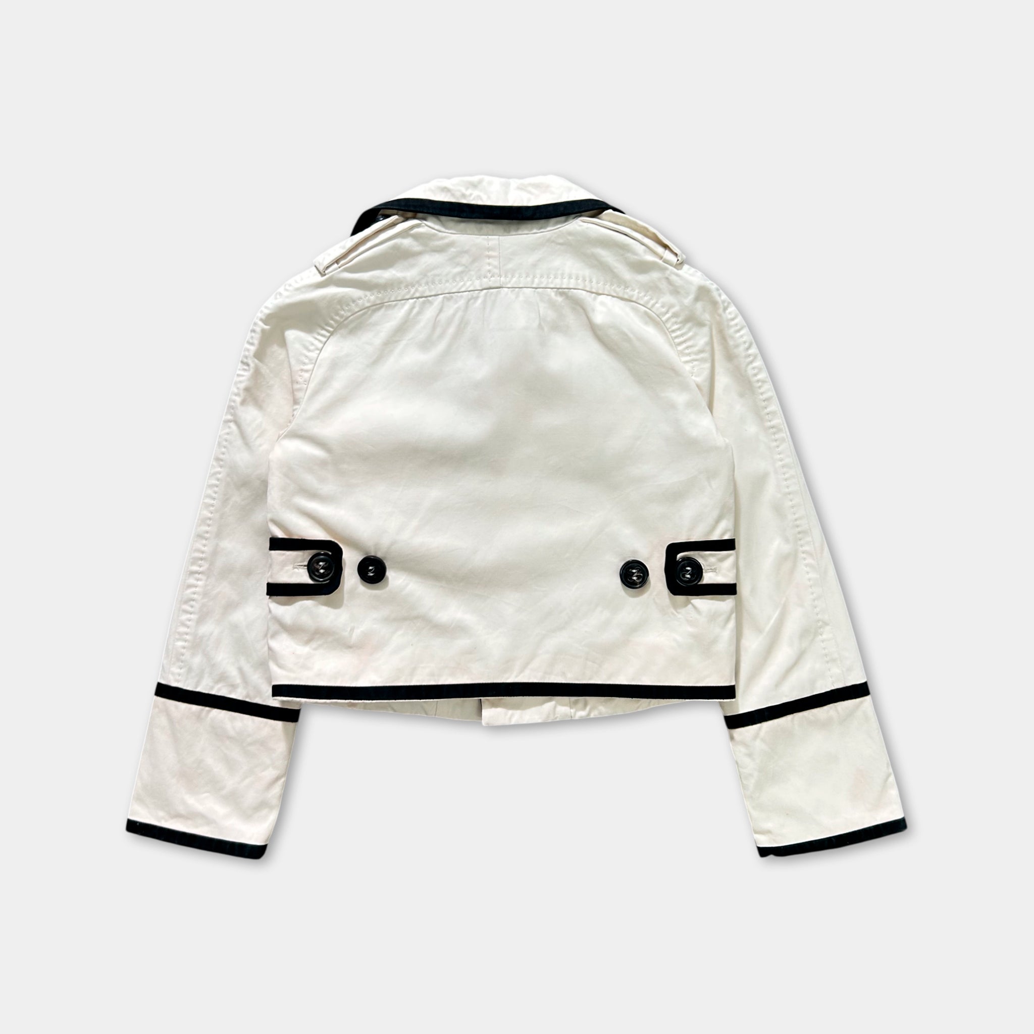 A white jacket with black trim and buttons, laid out against a white background.