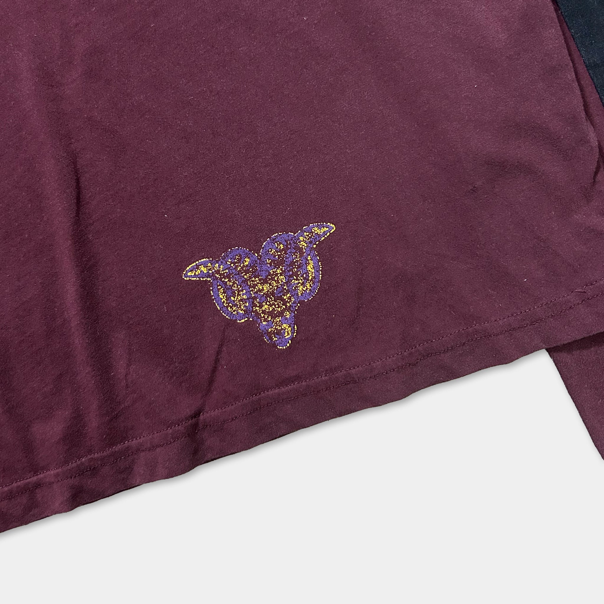 a close-up view of a dark-colored fabric with a decorative purple and gold pattern on it.