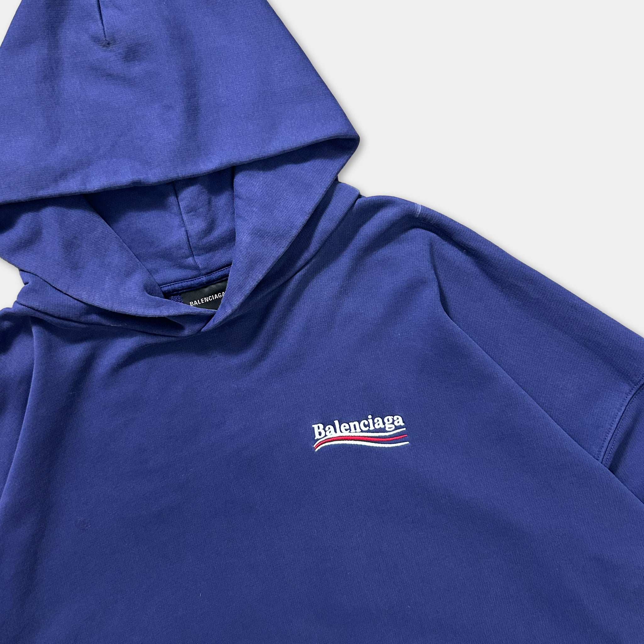 A blue hoodie with the Balenciaga logo prominently displayed on the front.