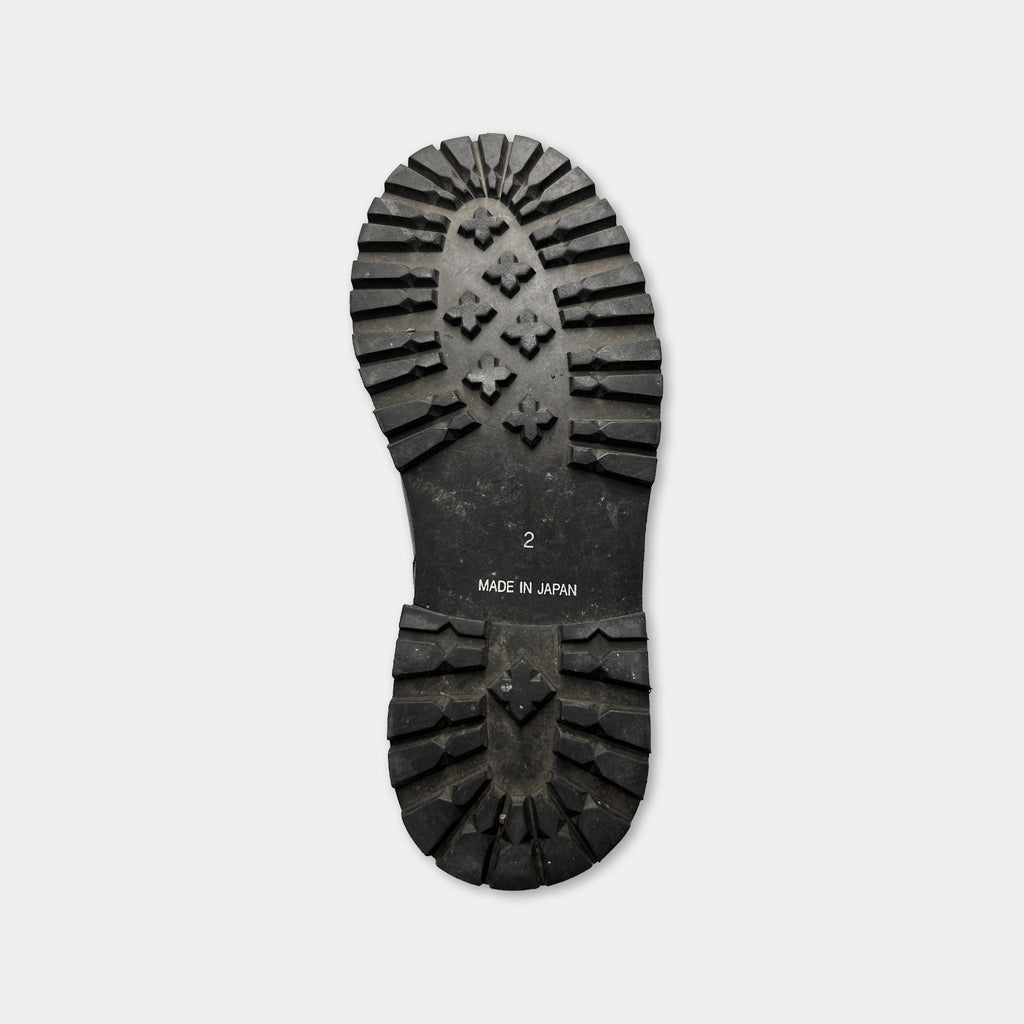 A black rubber sole of a shoe, with the text "MADE IN JAPAN" printed on it.
