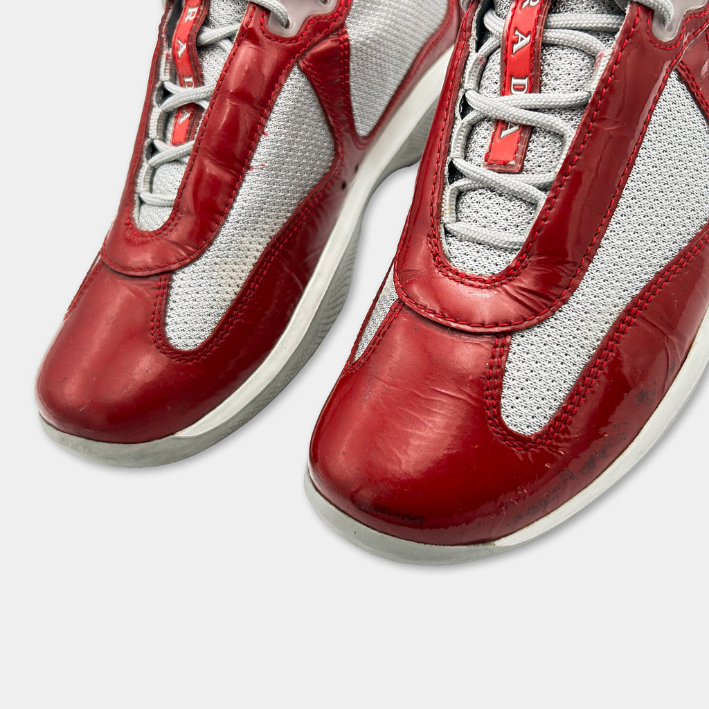 A close-up view of a pair of red and white athletic shoes with a textured pattern.