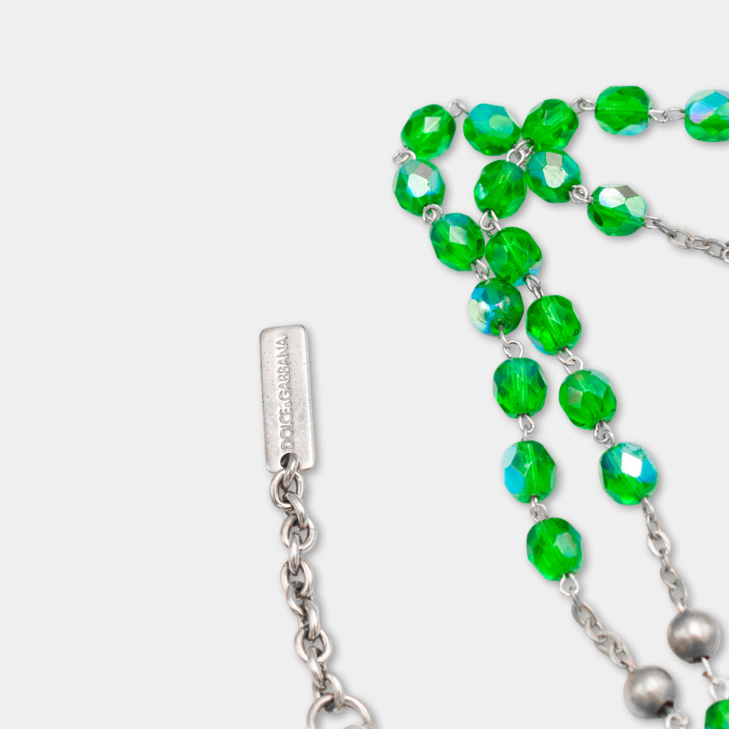 A close-up view of a necklace with green crystal beads and a metal clasp.