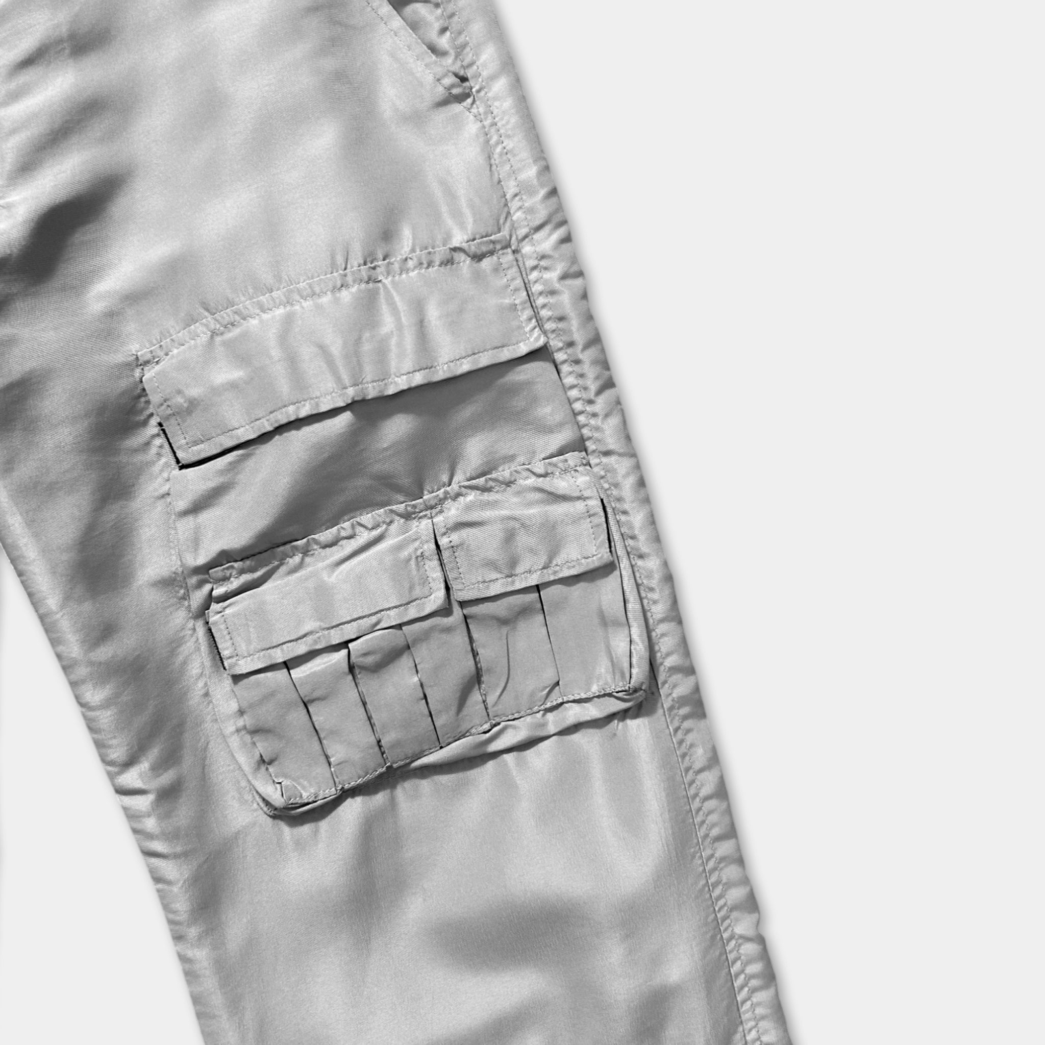 A close-up view of a pair of gray pants with multiple pockets.