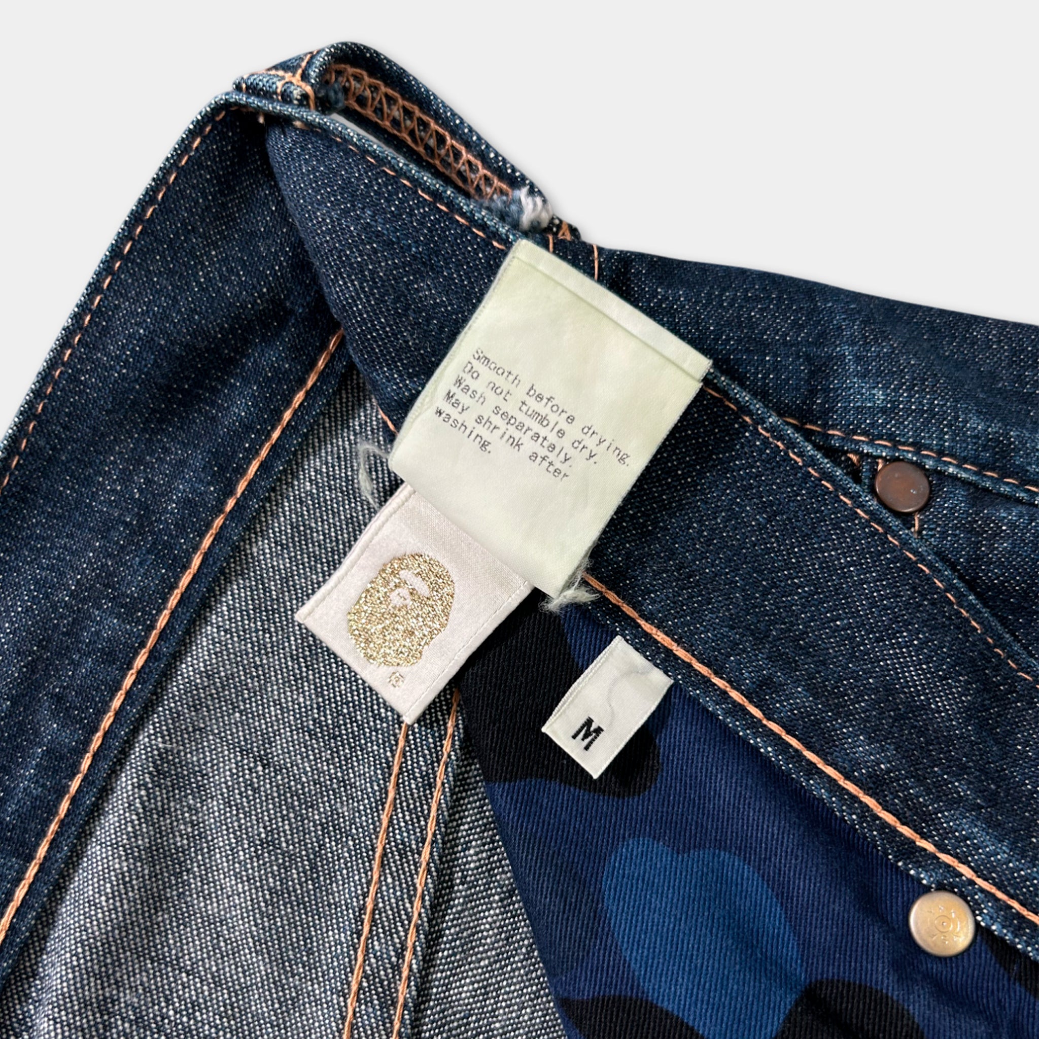 a close-up view of a pair of blue jeans with a label attached to the waistband.