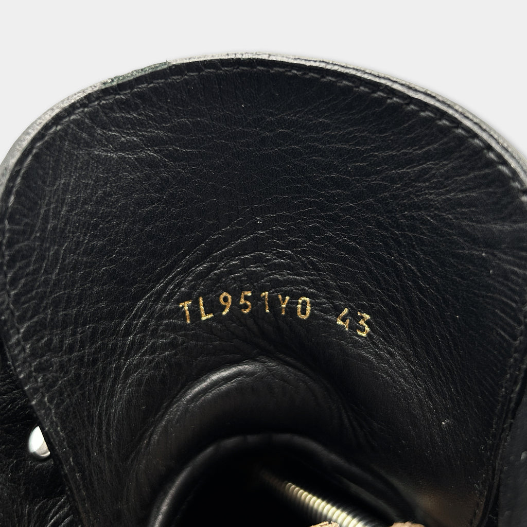 the interior of a black leather shoe, specifically the sole and the upper part of the shoe.