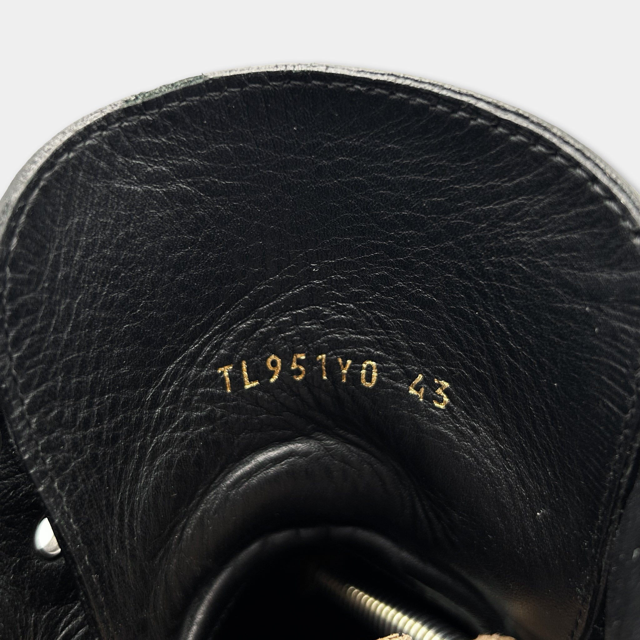 the interior of a black leather shoe, specifically the sole and the upper part of the shoe.
