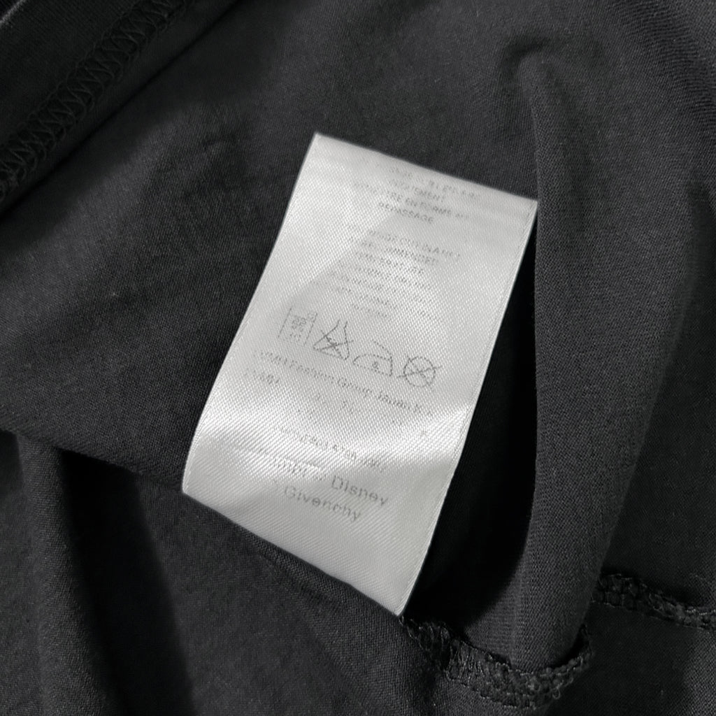 a close-up view of a black fabric with a white label attached to it. The label appears to contain text and symbols, but the image does not contain any text that can be transcribed within the given word limit.